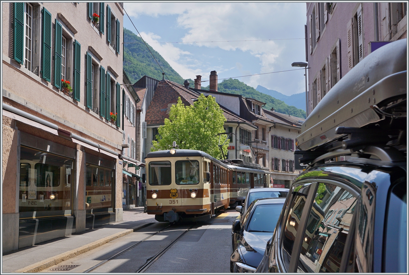 Der letzte noch in der braunen Farbgebung gehaltene AL Zug, bestehend aus dem AL Bt 351  Aigle  und dem AL BDeh 4/4 302  Leysin  ist in der Altstadt von Aigle auf der Fahrt zum Bahnhof von Aigle.

4. Juni 2023