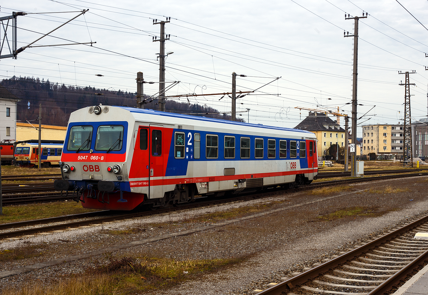 Der ÖBB 5047 060-8 (ÖBB BVT 5047 060-8), ein Dieseltriebwagen vom Typ Jenbacher J3995, rangiert am 14 Januar 2025 im Bahnhof Attnang-Puchheim, hinten steht noch der ÖBB 5047 024-4.

Der Triebwagen 5047 060-8 wurde 1991 von den Jenbacher Werken in Jenbach (Tirol) unter der Fabriknummer J3995-060 gebaut, der 5047 024-4 1989 unter der Fabriknummer J3995-024.

Die Reihe 5047 der Österreichischen Bundesbahnen (ÖBB) sind Dieseltriebwagen die im Regionalverkehr eingesetzt werden. Der Einsatz im Planverkehr begann 1987. Die Triebwagen wurden von den Jenbacher Werken gebaut. Die GySEV Raaberbahn und die Steiermarkbahn besitzen bzw. besaßen ebenfalls Triebwagen dieser Bauart.

Geschichte:
Von den ÖBB wurde 1983 ein Auftrag für sechs neue Dieseltriebwagen nach dem Vorbild der deutschen Baureihe 627 an die Jenbacher Werke vergeben. Das erste Fahrzeug wurde im Juli 1987 fertiggestellt und bei einer internationalen Pressefahrt nach Rosenburg am Kamp präsentiert. Nach erfolgreichem Einsatz auf den Strecken im niederösterreichischen Weinviertel, wo die sechs 5047er in einem rasch konzipierten „Sonderplan“ verwendet wurden, wurden für die ÖBB insgesamt 100 Triebwagen (mit geänderten Wandler-Getriebe) der Reihe 5047 und fünf Doppeltriebwagen-Garnituren der Reihe 5147 gebaut. Der Solo-5047 kostete damals 27 Mio. Schilling, ein Steuerwagen wäre mit 22 Mio. Schilling kaum günstiger gekommen. Daher kam für den 5147 die Lösung als Doppeltriebwagen in Form von zwei kurzgekuppelten Fahrzeugen zum Tragen.

Diese beiden Fahrzeugtypen ersetzten die alten Reihen 5044, 5144, 5145, 5146 und 5081, die teilweise noch aus der Zwischenkriegszeit stammten, technisch veraltet und am Ende ihrer wirtschaftlichen Nutzungsdauer angelangt waren. Im Gegensatz zu lokbespannten Zügen können die Triebwagen im Einmannbetrieb ohne Zugbegleiter (ÖBB-Bezeichnung „0:0“) gefahren und somit Personalkosten reduziert werden, da der Triebfahrzeugführer auch den Fahrscheinverkauf durchführen kann. Später wurden alle Fahrzeuge mit Fahrscheinautomaten ausgestattet, dies macht heute den Fahrscheinverkauf durch den Triebfahrzeugführer obsolet. Mit dem Einsatz dieser Fahrzeuge konnten die ÖBB auf zahlreichen Nebenstrecken eine Verbesserung des wirtschaftlichen Ergebnisses erzielen.

Die Triebwagen 5047 001 bis 032 wurden ab Werk in elfenbein, ultramarinblau und blutorange lackiert, 033 bis 100 in achatgrau, ultramarinblau und verkehrsrot.

Der Erfolg der Triebwagen veranlasste die beiden österreichischen Privatbahnen Steiermärkische Landesbahnen (heute Steiermarkbahn und Bus GmbH) und Raab-Ödenburg-Ebenfurter Eisenbahn (heute GYSEV Raaberbahn AG) ebenfalls zur Anschaffung von je zwei Fahrzeugen dieser Baureihe, die nach ÖBB-Regeln abgenommen wurden. Zum „Kilometerausgleich“ für den Einsatz von ÖBB-Fahrzeugen auf den Privatbahnen kommen diese Triebwagen auch auf ÖBB-Strecken zum Einsatz. Im Unterschied zu den ÖBB-Triebwagen haben die Privatbahnfahrzeuge Rollbandanzeigen an den Fronten.

Weiters beschaffte die NVAG (heute Norddeutsche Eisenbahngesellschaft Niebüll) einen Triebwagen, welcher auf der Strecke Niebüll – Dagebüll im Einsatz steht. Dieser hat eine andere Inneneinrichtung mit erster und zweiter Klasse.

Technik:
Die gesamte Antriebsanlage unterflur angeordnet. Seine Kraft erzeugt der Dieseltriebwagen Reihe 5047 aus einem 12-Zylinder-V-Motor mit Abgasturbolader und Ladeluftkühlung vom Typ MTU 12V183TC12 (Mercedes-Benz OM444) mit 21,93 l Hubraum und einer Leistung von 419kW (570PS). Derselbe Motor ist auch in den Triebwagen DB-Baureihe 628.2 eingebaut. Die Kraftübertragung geschieht über ein Turbogetriebe mit zwei Drehmomentwandlern System Föttinger sowie einer Hydrodynamischen Bremse. Um die Kühlleistung des Getriebeöles zu erhöhen, wird bei der Betätigung der Hydrobremse die Motordrehzahl erhöht. Angetrieben wird das Drehgestell auf der dem Mehrzweckraum abgewandten Seite. Dieses Drehgestell nimmt auch die Magneten für die Indusi bzw. in neuerer Zeit der PZB auf. Am Laufdrehgestell unter dem Mehrzweckraum ist die Magnetschienenbremse befestigt.

TECHNISCHE DATEN:
Spurweite: 1.435 mm (Normalspur)
Achsformel: 2'B'
Länge über Puffer: 25.420 mm
Drehzapfenabstände: 16.600 mm
Achsabstand im Drehgestell: 2.000 mm
Treib- und Laufraddurchmesser: 840 mm (neu)
Eigengewicht: 45 t
Motor: wassergekühlter V12-Zylinder Daimler-Benz Unterflur-Dieselmotor mit Abgasturbolader und Ladeluftkühlung vom Typ DB OM 444 A bzw. MTU 12V183TC12 (der Motor war eine Entwicklung von MB wurde aber von MTU hergestellt).
Motorhubraum: 21,93 Liter
Motorleistung: 419kW (570PS)
Höchstgeschwindigkeit: 120 km/h
Leistungsübertragung: dieselhydraulisch (Turbogetriebe)
Sitzplätze: 68 (in der 2. Klasse)