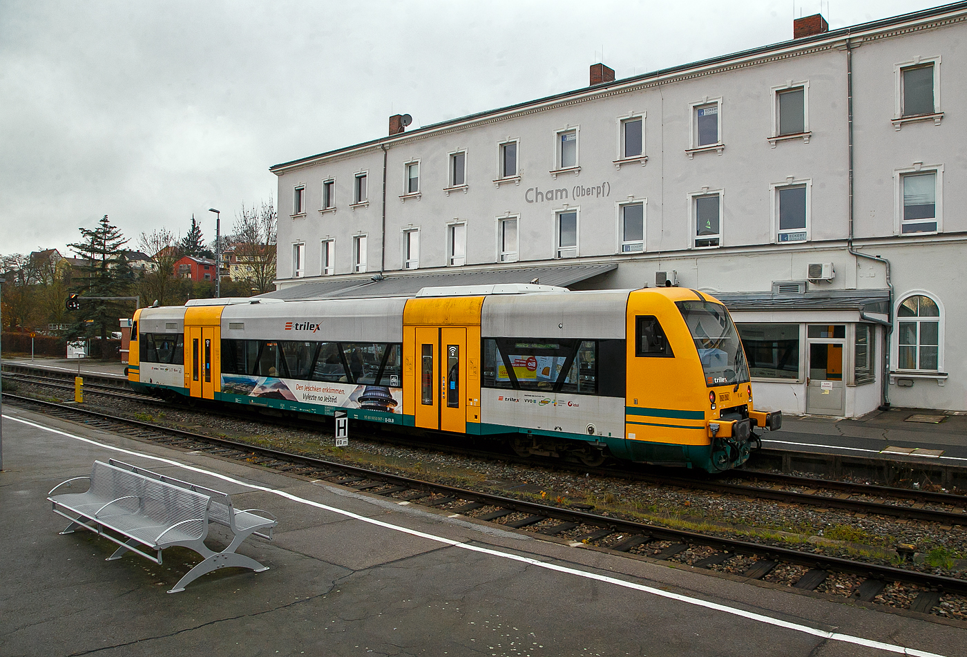 Der Trilex VT 067 alias 650 067-1 (95 80 0650 067-1 D-DLB) ein STADLER Regio-Shuttle RS1 der „oberpfalzbahn“ eine Marke der „Die Länderbahn GmbH (DLB)“, steht am 22.11.2022 in Cham (Oberpfalz), als RB 29 (ex OPB 5) nach Waldmünchen, zur Abfahrt bereit. Dieser ist hier noch in „trilex“-Farbgebung, die auch zur „Die Länderbahn GmbH (DLB)“ gehört.

Die 13 STADLER Regio-Shuttle RS1 (Baujahr 2000/03) der „oberpfalzbahn“ wurden 2013/2014 modernisiert (komplett entkernt und umgebaut). Für die kleinen Fahrgäste ist eine Kinderspielecke entstanden. Verbessert wurde auch die Fahrgastinformation im Fahrzeug. Neue Monitore wurden im Bereich des Aus- und Einstiegs eingebaut und informieren über den aktuellen Verlauf der Fahrt und die weiteren Anschlüsse. Zwei Mehrzweckbereiche pro Fahrzeug bieten ausreichend Platz für bis zu sechs Fahrräder, Kinderwagen und Gepäck. Der stufenlose Einstieg ermöglicht auch mobilitätseingeschränkten Personen einen bequemen Zugang. Das Fahrzeug bietet Platz für ca. 155 Fahrgäste (72 Sitzplätze). 

Der Antrieb erfolgt über 2 MAN Dieselmotoren mit je 257 KW (350 PS) Leitung hydromechanisch über 2 Voith-Diwabus Getriebe U 864, die Höchstgeschwindigkeit beträgt 120 km/h.