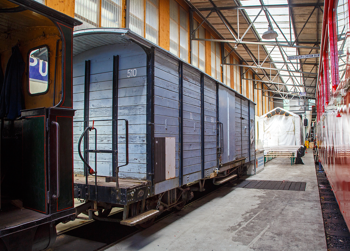 Der vierachsige gedeckte G�terwagen mit einer Bremserb�hne, ex TL  K⁴ 510 (Tramway de Lausanne / Stra�enbahn Lausanne), heute im Bestand der Museumsbahn Blonay–Chamby, hier am 27.05.2023 in der Halle der (BC) in Chaulin.

Der Wagen wurde 1910 von der SWS in Schlieren (Schweizerische Wagons- und Aufz�gefabrik AG) gebaut. Von 1964 bis 1993 war er bei der AOCM (heute tpc) als DZ� 192 (Gep�ckwagen) im Einsatz. Im Dezember 1993 ging er an die Museumsbahn BC.

Ab 1906 trug das Tramnetz von Lausanne auch zum Transport unterschiedlichster G�ter bei, Waggons aus der Nestl�-Fabrik in Bercher, Kohle f�r die Fabrik Pierre de Plan, Bau- und Aushubmaterial usw.. Mehr als 52.000 Tonnen, das sind rund 5.200 Waggons, die f�r den Bau des Trinkwasserreservoirs Calvaire und den Bau des Bundesgerichtshofs in Mont-Repos transportiert wurden. Landwirtschaftliche Produkte, wie Gem�se, Weizen, R�ben, sowie frisch produzierter Milch, kommen dank der „l�ndlichen“ Linien von Montheron und Jorat „in die Stadt“. 

Der Wagen Nr. 510 wurde 1910 von der Stadt Lausanne erworben. Er verf�gt �ber eine gro�e Kapazit�t und er war einer der ersten in Dienst gestellten Drehgestellwagen. Er wurde insbesondere f�r den Transport von Vieh zum Schlachthof Borde eingesetzt. Bis zur Einstellung des Stra�enbahnnetzes im Jahr 1964 dienten zwei Triebwagen, die von mehreren ausgemusterten Triebwagen unterst�tzt wurden, dem G�terverkehr. 

Dieser Wagen ging anschlie�end an die Aigle-Ollon-Monthey-Champ�ry-Bahn (AOCM) und wurde im G�terverkehr zwischen Aigle und Monthey eingesetzt, bevor er im Dezember 1993 in die Blonay-Chamby-Sammlung aufgenommen wurde.

TECHNISCHE DATEN:
Typ: K
Baujahr: 1910
Hersteller: SWS Schlieren
Spurweite: 1.000 mm (Meterspur)
Achsanzahl: 4
L�nge �ber Puffer: 9.700 mm
Wagenkastenl�nge ohne Plattform: 7.800 mm
Drehzapfenabstand: 5.200 mm
Achsabstand im Drehgesell: 1.300 mm
Breit: 2.000 
Eigengewicht: 7,0 t
Nutzlast: 10 t

Quellen: Museumsbahn BC