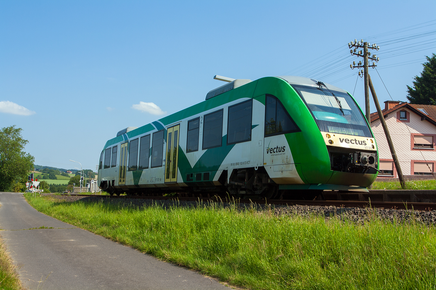 Der VT 202 (95 80 0640 102-9 D-VCT), ein Alstom Coradia LINT 27, der damaligen vectus Verkehrsgesellschaft mbH, als RB 28  Oberwesterwaldbahn  von Altenkirchen nach Westerburg, am 09 Juli 2013 beim Haltepunkt Enspel (Ww). 

Damals wurde die Linie noch als RB 28 geführt, mit dem Fahrplanwechsel am 14.12.2014 wurde Linie zur RB 90 „Westerwald-Sieg-Bahn“ und zwischen Siegen über Au/Sieg und Altenkirchen nach Limburg/Lahn durchgebunden.

Auch den Triebwagen gibt es in dieser Farbgebung nicht mehr, der Triebwagen wurde 2004 von der Alstom LHB GmbH (vormals LHB - Linke-Hofmann-Busch GmbH) in Salzgitter-Watenstedt unter der Fabriknummer 1187-002 für die vectus Verkehrsgesellschaft mbH gebaut, mit dem Fahrplanwechsel am 14.12.2014 wurden alle Fahrzeuge der vectus nun Eigentum der HLB, wo er heute noch im Einsatz ist.

Zur LHB - Linke-Hofmann-Busch GmbH
Die Linke-Hofmann-Busch GmbH (LHB) war bis Anfang der 1990er Jahre Teil der Salzgitter-Gruppe. 1994 kaufte die GEC-Alsthom 51% der Anteile der LHB. Der Konzern wurde 1998 in Alstom LHB umbenannt. Seit April 2009 firmiert das Unternehmen als Alstom Transport Deutschland GmbH – der Name Linke-Hofmann-Busch ist somit nach 170 Jahren Unternehmensgeschichte verschwunden, die Adresse Linke-Hofmann-Busch-Straße 1 in Salzgitter erinnert noch an die Geschichte der Firma an diesem Standort.
