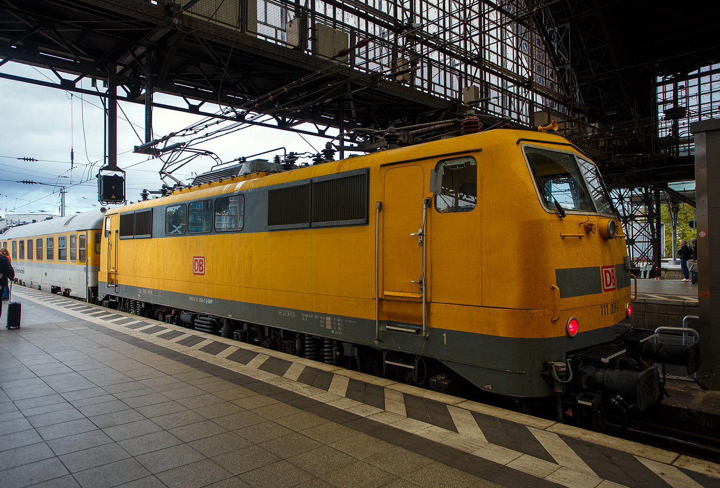 Die 111 059-2 (91 80 6111 059-2 D-DBMP) der DB InfraGO AG, ex DB Netz AG / DB Netz Instandhaltung – Fahrwegmessung am 21 Oktober 2025, mit einem Messzug der DB Systemtechnik GmbH (Minden/Westf.), im Hauptbahnhof Köln.

Die Lok wurde 1976 von Henschel & Sohn in Kassel unter der Fabriknummer 31905 gebaut und an die Deutsche Bundesbahn geliefert. Im Jahr 20014 ging sie von der DB Regio Hessen an die DB Netz AG (heute DB InfraGO AG). 

Der Zug bestand zudem aus dem Einheitsmesswagen D-DB 63 80 99-92 007-3 Dienstüm 313 und dem Steuerwagen D-DB 73 80 80-91 310-1 Bpmbdzf 296.3.

Der Steuerwagen ist ein ehemaliger 2. Klasse behindertengerechter InterCity-Steuerwagen mit Fahrradabteil, heute mit Messarbeitsplätzen. Insgesamt sollen fünf dieser Steuerwagen von der DB Systemtechnik übernommen worden sein. Dieser Wagen wurde 1990 vom Raw Halberstadt unter der Fabriknummer 90.Bm167 und als D-DR 51 50 21-80 078-1 der Gattung Bm 2180 eingereiht. Zum 01.01.1994 ging er als D-DB 51 80 21-80 078-5 Bom 281.1 in den Bestand der DB AG über. 1999 wurde er im PFA Weiden (Partner für Fahrzeugausstattung GmbH) zum InterCity-Steuerwagen D-DB 73 80 80-90 110-6 Bpmbdzf 297.3 der DB Fernverkehr AG umgebaut. Der Steuerwagen, 2. Klasse, behindertengerecht, mit Fahrradabteil wurde 2002 zum D-DB 73 80 80-91 310-1 Bpmbdzf 296.3 umgebaut, von 2006 im „München-Nürnberg-Express“ im Einsatz bis er 2021 an die DB Systemtechnik. Heute beherbergt der Steuerwagen hinter dem Führerstand nun 3 Messarbeitsplätze. Der Wagen findet im Wendezugbetrieb bis 200 km/h auf dem Netz der Deutschen Bahn AG als eigenständiger Messwagen oder in Verbindung mit Einheitsmesswagen Verwendung. Der Wagen hat die RIC Zulassung für eine Höchstgeschwindigkeit von 200 km/h.

Der Einheitsmesswagen wurde 1976 von MBB (ex WMD - Waggon- und Maschinenbau GmbH Donauwörth) unter der Fabriknummer 09036 als Einheitsmeßwagen der Gattung Dienstüm 313. Die Wagen entsprachen in der technischen Ausführung und Fahrleistungen den DB Reisezugwagen und waren für Höchstgeschwindigkeiten bis 300 km/h zugelassen. Alle Dienstüm 313 waren mit einer Grund-Messausrüstung ausgestattet, die aus einer digitalen Geschwindigkeits-, Weg- und Zeitmesseinrichtung, einer Analogregistrierung, Zug-Druckkraft-Messgeräten und einer Mess- und Meldeanlage für die Achslagertemperatur bestand. 

In enger Zusammenarbeit mit der Deutschen Bundesbahn entwickelte und fertigt MBB Einheitsmesswagen für Schnellfahrversuche bis 300 km/h. Bei gleicher Grundkonzeption und entsprechender Ausrüstung werden die Fahrzeuge für Fahrleitungs- und Leistungsmessungen eingesetzt. 
Folgende Untersuchungen sind durchführbar: 
•	Laufverhalten der Schienenfahrzeuge bei 200 km/h und mehr,
•	aerodynamisches Verhalten bei Zugbegegnungen und Vorbeifahrt an Bauwerken,
•	Geräuschentwicklung,
•	Bremswirkung,
•	Zugkraftmessung,
•	Überprüfung des Oberbaus,
•	Leistungsmessung, sowie 
•	das Verhalten der Fahrleitung und Stromabnehmer bei 200 km/h und mehr.

Die Messwagen entsprechen den Bestimmungen für den internationalen Verkehr, den Vorschriften und technischen Lieferbedingungen der Deutschen Bundesbahn, den UIC- und RIC-Vorschriften und sind somit in vielen europäischen Länder zugelassen.

Der Wagenkasten besteht aus einer robusten Schweißkonstruktion in Profilbauweise aus Stahl in der Güte St 37 bzw. St 52. Die Ausführung und Ausstattung entspricht dem bei deutschen Reisezugwagen mit hohem Komfort. Schalldämmung und Wärmeisolierung, erschütterungsfreier Einbau von Verkleidungen, Wänden, Decken und Schränken,  wartungsleichte und verschleißarme Bauteile sowie zweckmäßige Gestaltung der Arbeits- und Wohnräume standen bei der Konzipierung des wagenbaulichen Teils im Vordergrund.

Die Messwagen sind in folgende Räume aufgeteilt: 
-	Führerstand 1 (Hauptführerstand), 
-	Dieselraum, 
-	Material- und Werkzeuglager, Werkstatt, 
-	Messraum, 
-	Auswerteraum,
-	Wohn- und Schlafkabine mit Waschgelegenheit, 
-	Küche mit elektr, Kocher, Spülbecken u. Kühlschrank, 
-	WC mit Waschgelegenheit, 
-	Garderobe, 
-	Führerstand 2. 

Die beiden Führerstände an den Kopfenden sind mit Kontrollgeräten und einer Gegensprechanlage zur Verbindung mit dem Lokführer ausgerüstet. 

Im Werkstattraum sind die Schaltschränke für Hoch- und Niederspannung sowie für die Klimaanlage untergebracht. Eine Werkbank vervollständigt die Ausstattung. Im Messraum sind Stahlschränke für die Messausrüstung, die mit der installierten Standard-E-Ausstattung verdrahtet werden kann, eingebaut. 
Alle Wagen dieser Bauart sind mit einer Grund-Messausrüstung ausgestattet, die aus einer digitalen Geschwindigkeits-, Weg- und Zeitmesseinrichtung, einer Analogregistrierung, Zug-Druckkraft-Messgeräten und einer Mess- und Meldeanlage für die Achslagertemperatur besteht. Eine Besprechungsanlage mit Vielfachgegensprechtechnik ermöglicht die Kommunikation innerhalb des Messwagens.

Der Auswerteraum ist mit einer Eckbank, einem Tisch und Sesseln eingerichtet.

TECHNISCHE DATEN des Einheitsmesswagen D(Mess)m 313.0:
Spurweite: 1.435 mm (Normalspur)
Länge über Puffer: 26.400 mm
Drehzapfenabstand: 19.000 mm
Achsstand im Drehgestell:  2.500 mm
Laufraddurchmesser: 950 mm (neu)
Drehgestelle: Bauart Minden- Deutz, schwer
Dienstgewicht: 61,5 t
Zul. Höchstgeschwindigkeit: 200 km/h
