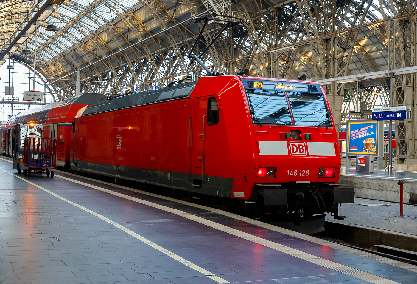 Die 146 128 (91 80 6146 128-4 D-DB) der DB Regio – Mitte steht am 21.03.2023, mit dem RE 20 „Main-Lahn-Express“ nach Limburg (Lahn), zur Abfahrt bereit.

Die TRAXX P160 AC1 wurde 2005 bei Bombardier in Kassel unter der Fabriknummer 34061 gebaut. Die Type TRAXX P160 AC1 (2. Bauserie) wurde in den Jahren 2003 bis 2005 ausgeliefert. Diese Loks sind eine technische Variante der Baureihe 185, wobei diese aber nur f�r den Einsatz unter 15 kV 16,7 Hz vorgesehen sind. Daher hat DB Regio diese Loks als Baureihe 146.1 eingeordnet. Sie haben eine wesentlich h�here Nennleistung als die urspr�ngliche BR 146.0 (bei diesen wurde 2010 ein leistungssteigernder Umbau durchgef�hrt). 

TECHNISCHE DATEN:
Spurweite: 1.435 mm 
Achsanordnung: Bo`Bo` 
L�nge �ber Puffer: 18.900 mm 
Dienstgewicht: 84 t
Radsatzlast: 21 t 
Nennleistung (Dauerleistung): 5.600 kW (7.600 PS) 
Anfahrzugkraft: 300 kN 
Antrieb: Hohlwellenantrieb 
H�chstgeschwindigkeit: 160 km/h 
Fahrdrahtspannung: 15 kV 16,7 Hz 
