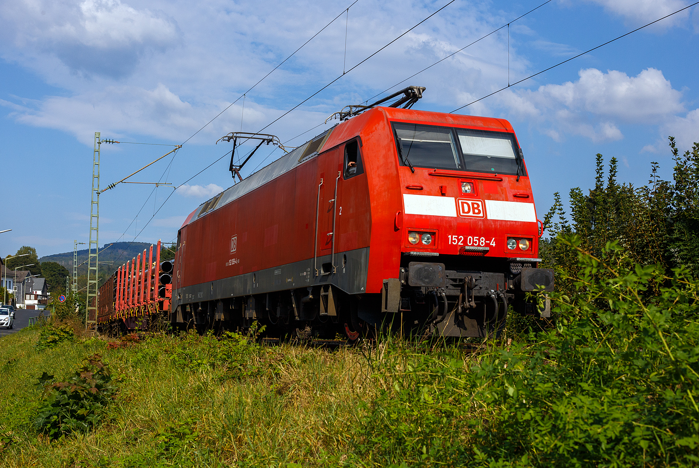 Die 152 058-4 (91 80 6152 058-4 D-DB) der DB Cargo Deutschland AG fährt am 19 September 2024, mit einem Röhrenzug durch Kirchen (Sieg) in Richtung Köln. Der Zug bestand aus Drehgestellflachwagen mit Niederbindeeinrichtungen der Gattungen Snps 719.1 / Sns 727, beladen mit HFI-längsnahtgeschweißte Stahlrohre Ø 323.9 (DN/NW 300 mm bzw. 12 ¾ Inch) in Herstellungslänge vom 12 m, des Herstellers der Salzgitter Mannesmann Line Pipe GmbH in Siegen (ex RW Fuchs). 

Die Siemens ES64F wurde 1998 noch von Krauss-Maffei in München-Allach unter der Fabriknummer 20185 gebaut, der elektrische Teil wurde von DUEWAG unter der Fabriknummer 91944 geliefert.