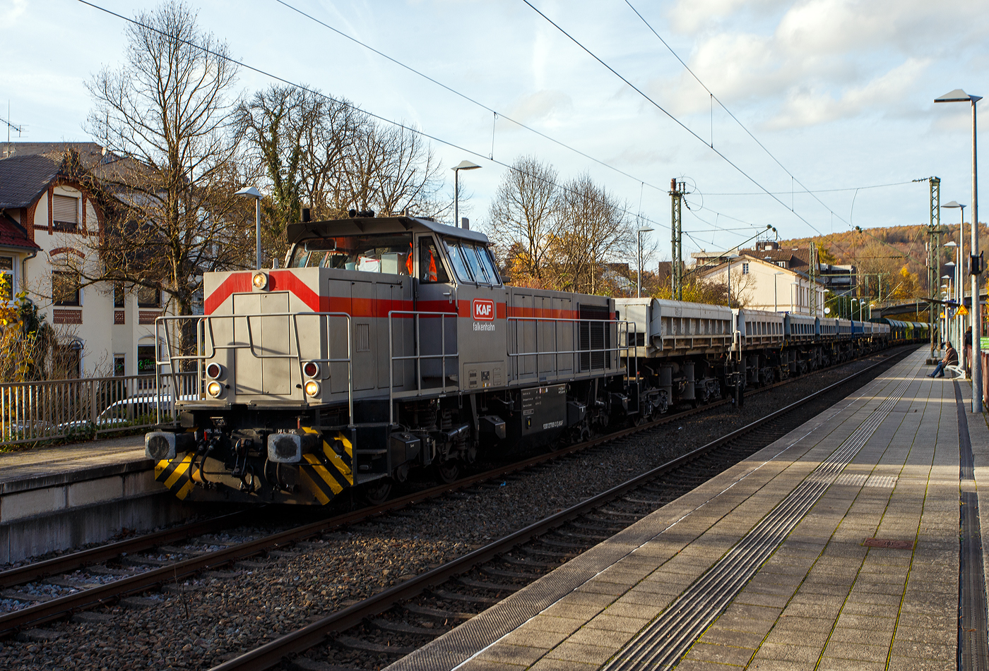 Die 277 809-0  Elmi“ (92 80 1277 809-0 D-KAF), eine Vossloh MaK G 1700 BB der KAF - Falkenhahn Bau AG (Kreuztal), fährt am 04 November 2025 mit einem langen Schotterzug durch Kirchen/Sieg in Richtung Betzdorf/Sieg. Im Bahnhof Kirchen hat sie jedoch etwas länger Hp 0 und ich kann so ein paar einzelne Wagen ablichten.

Die Vossloh MaK G 1700 BB wurde 2001 von Vossloh in Kiel 2001 unter der Fabriknummer 1001113 gebaut und an die NE - Neusser Eisenbahn geliefert. Nach dem Zusammenschluss der HGK und der NE zur RheinCargo GmbH & Co. KG, fuhr sie noch als RHC 277 809-0. Anfang 2014 ging sie an die Vossloh Locomotives GmbH (92 80 1277 809-0 D-VL) und war 1 ½ Jahre als Mietlok unterwegs, bis sie im Juni 2015 an die Michael Bugdoll Bau- und Sicherungsarbeiten e. K in Dorsten ging, als diese konnte ich sie auch mal ablichten. Seit 01.01.2021 ist die Lok nun bei der KAF - Falkenhahn Bau AG (Kreuztal), hier hat sie aber ihren Namen  Elmi“ behalten.