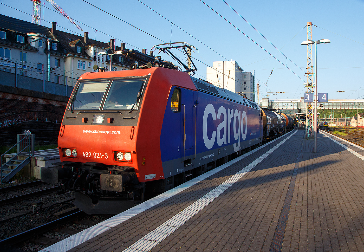 Die an die TX Logistik AG vermietete Re 482 021-3 (91 85 4482 021-3 CH-SBBC) der SBB Cargo AG fährt am 25.Mai 2023, mit einem Kesselwagenzug durch den Hauptbahnhof Siegen in Richtung Dillenburg bzw. Frankfurt.

Die TRAXX F140 AC1 wurde 2003 von Bombardier in Kassel unter der Fabriknummer 33578 gebaut und an die SBB Cargo AG geliefert. Sie hat die Zulassungen für die Schweiz und Deutschland. Die Re 482 wurden aber nicht auf ETSC nachgerüstet, daher sieht diese Loks meist nur in Deutschland. 

