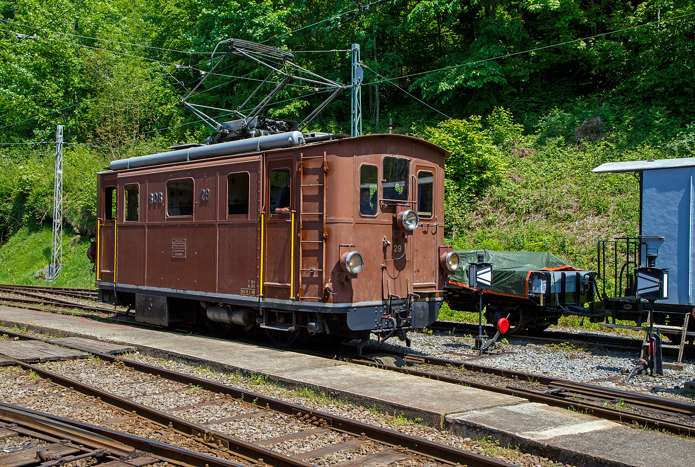 Die ex BOB HGe 3/3 29 der Museumsbahn Blonay–Chamby rangiert  am 27.05.2023 im Museumsareal in Chaulin.

Die elektrischen Lokomotiven für den gemischten Zahnrad- und Adhäsionsbetrieb HGe 3/3 29 wurde 1926 von der SLM - Schweizerische Lokomotiv- und Maschinenfabrik in Winterthur unter der Fabriknummer 3127gebaut, der elektrische Teil wurden von der MFO - Maschinenfabrik Oerlikon geliefert.

Die Berner Oberland-Bahn (BOB) ist eine Schmalspurbahn im Berner Oberland in der Schweiz. Sie führt von Interlaken Ost über Zweilütschinen nach Lauterbrunnen beziehungsweise Grindelwald. Diese Meterspurbahn wurde am 1. Juli 1890 eröffnet  und am 17. März 1914 elektrifiziert. Im Jahr 1914 wurden acht Elektrolokomotiven für den gemischten Zahnrad- und Adhäsionsbetrieb (HGe 3/3 21 bis 28) in Dienst gestellt, um die Dampftraktion zu ersetzen. Die HGe 3/3 Nr. 29 wurde 1928 zur Stärkung des Parks erworben. Sie wurden bis Mitte der 1960er Jahre genutzt, danach wurden einige davon in Reserve gehalten. Die HGe 3/3 29 wurde 2014 an Blonay-Chamby verkauft.

Diese elektrischen Lokomotiven für den gemischten Zahnrad- und Adhäsionsbetrieb der Baureihe HGe 3/3 prägten jahrelang das Erscheinungsbild der Berner Oberland-Bahn. 

Mit den HGe 3/3 wurde das bewährte Konzept der zehn vorhandenen Dampflokomotiven HG 3/3 mit getrenntem Adhäsions- und Zahnradantrieb übernommen. Ein starker Elektromotor wirkte auf die drei mit Stangen gekuppelten Achsen im Adhäsionsantrieb. Ein zweiter baugleicher Motor diente als Antrieb des Treibzahnrads. Das zweite Zahnrad war nicht angetrieben und fungierte als Bremszahnrad. Während im Adhäsionsbetrieb ein Elektromotor verwendet wurde, standen im Zahnradbetrieb beide Motoren in Serie geschaltet im Einsatz. Auch war eine Widerstandsbremse eingebaut.

Typisches äußeres Merkmal der meterspurigen HGe 3/3 21 bis 28 und der nachgelieferten HGe 3/3 29 war ein wuchtiger Pantograf mit zwei weit voneinander angebrachten Schleifstücken.

Nachdem an den Lokomotiven 21 bis 28 verschiedene kleinere Verbesserungen vorgenommen wurden, wurde 1926 eine weitere Lokomotive, diese 29, in einer in weiteren Details verbesserten Ausführung nachbeschafft. Äußerlich ist die nachbeschaffte Lokomotive daran zu erkennen, dass das mittlere Frontfenster gegenüber den beiden seitlichen Frontfenstern sichtbar erhöht ist.

Nach der Inbetriebnahme der elektrischen Personen- und Gepäck-Triebwagen MOB ABDeh 4/4 301 bis 303 im Jahre 1949 wurden die Lokomotiven ins zweite Glied verdrängt. Mit der kontinuierlichen Lieferung weiterer Triebwagen sowie der Bildung von Pendelzügen wurden die Lokomotiven auch wegen der geringen Höchstgeschwindigkeit immer weniger eingesetzt, Stück für Stück ausgemustert und dann abgebrochen. Letztmals waren die beiden noch vorhandenen Lokomotiven HGe 3/3 24 und HGe 3/3 29 im Jahre 2013 fahrplanmäßig vor Sonder- und Dienstzügen im Einsatz.

TECHNISCHE DATEN:
Spurweite: 1.000 mm
Achsfolge: Cz
Zahnstangensystem: Riggenbach
Länge über Puffer: 8.240 mm
Achsabstand: 2 x 1.750 = 3.500 mm
Treibraddurchmesser:  910 mm
Leergewicht: 36,5 t
Leistung: 2 x 150 kW = 300 kW (420 PS), bei Adhäsion 150 kW
Übersetzung: Adhäsion 1:4.27 / Zahnrad 1:6.00
Höchstgeschwindigkeit: 40 km/h (Adhäsion) / 15 km/h (Zahnrad)
Anhängelast: 125 t auf 25 ‰; 85 t auf 90 ‰ nach Lauterbrunnen; 60 t auf 120 ‰ nach Grindelwald
Stromsystem: 1:500 V DC (Gleichstrom)