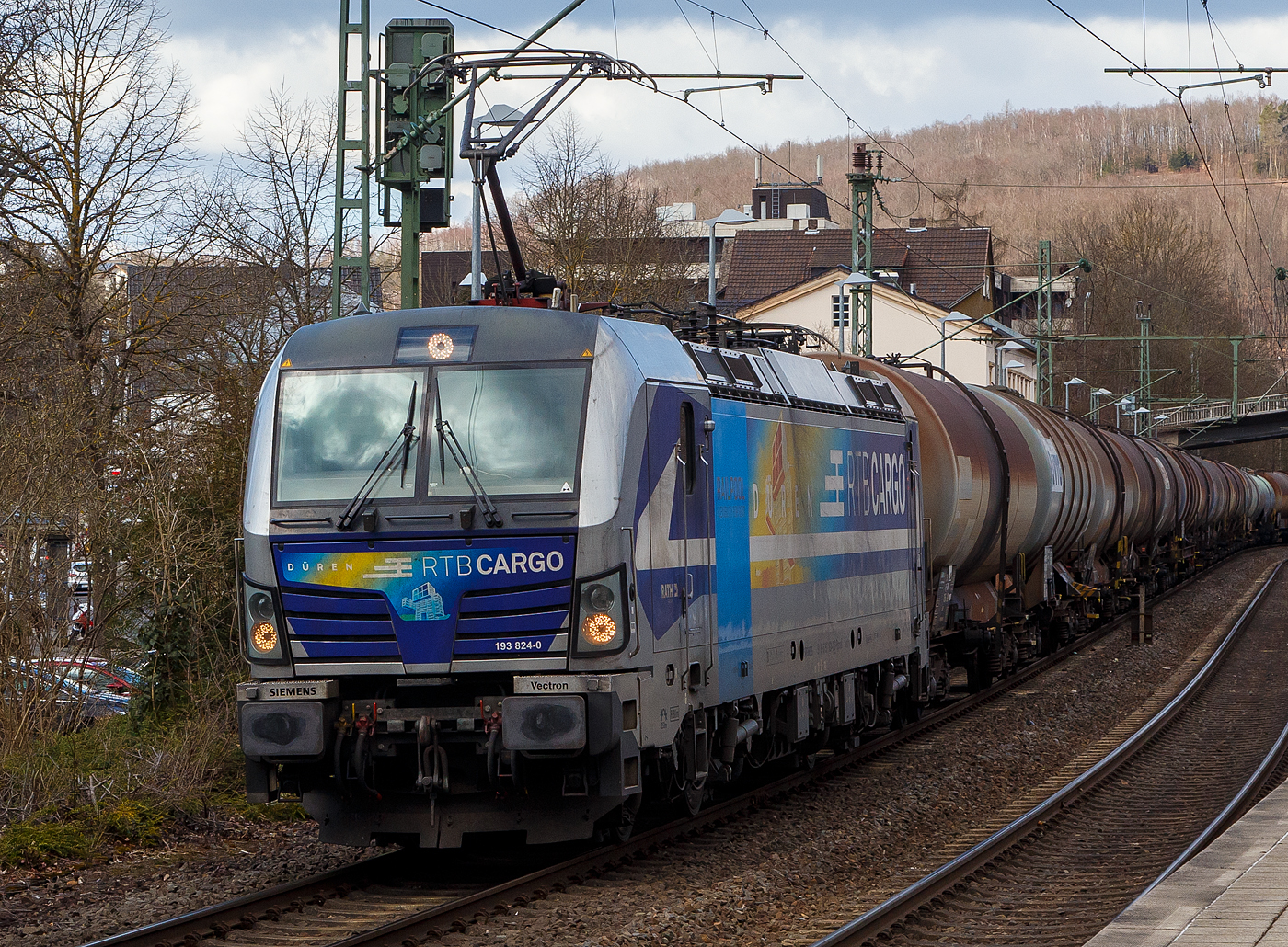 Die für die Rurtalbahn Cargo GmbH fahrende Vectron 193 824-0   Düren  (91 80 6193 824-0 D-Rpool) der Railpool GmbH (München), fährt am 19.03.2021 mit einem Kesselwagenzug durch den Bahnhof Kirchen (Sieg) in Richtung Köln.

Die SIEMENS Vectron AC (200 km/h - 6.4 MW) wurde 2016 von SIEMENS Mobilitiy in München unter der Fabriknummer 22054 gebaut. Sie hat die Zulassung für D/ A und H (RO durchgestrichen).