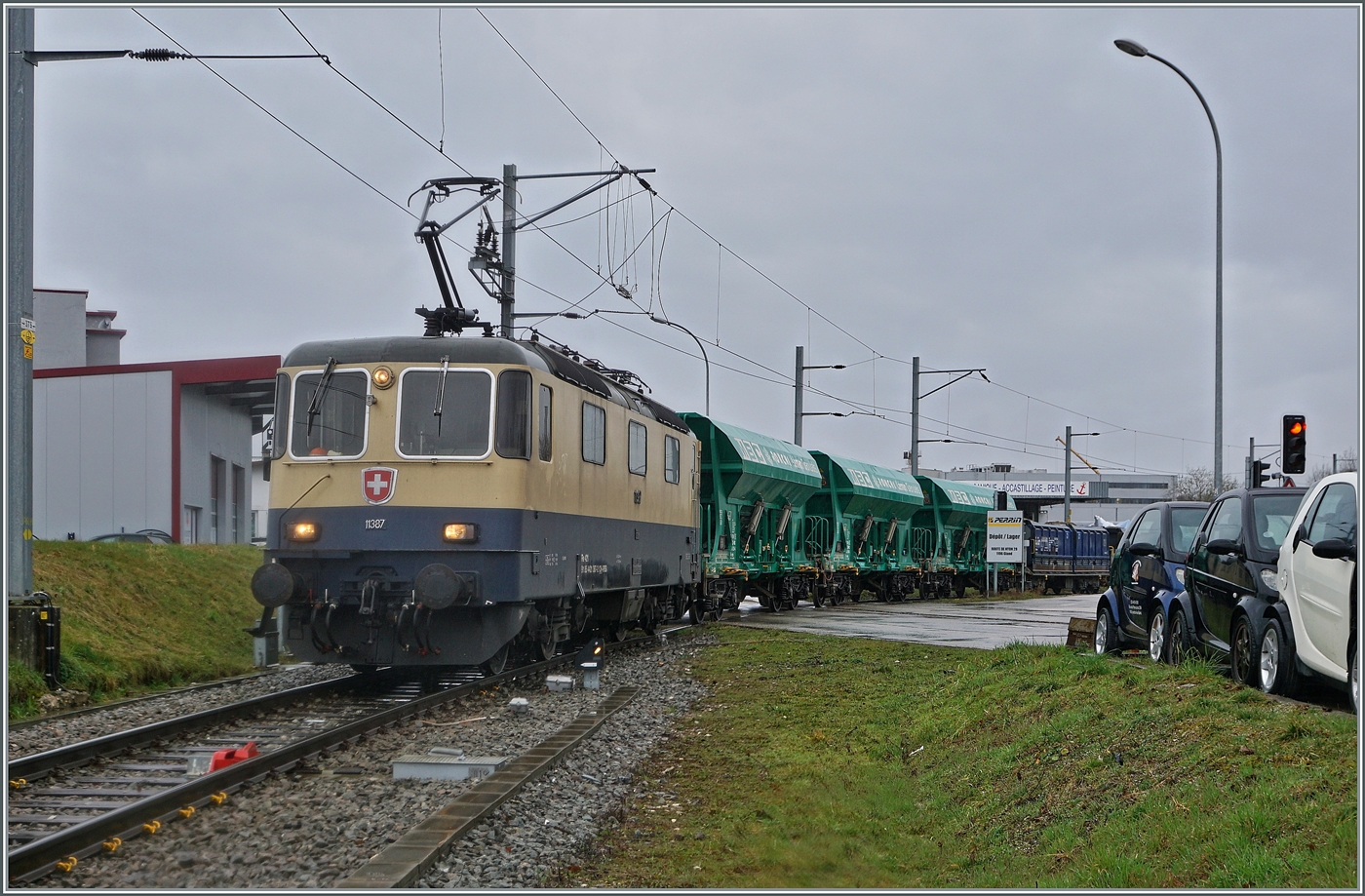 Die IRSI/IGE  Rheingold  Re 4/4 II 11387 (Re 421 387-2) im Dienste der BAM MBC verl�sst mit ihrem Kieszug nach Apples das Industriegel�nde bei Gland.

22. Feb. 2024 