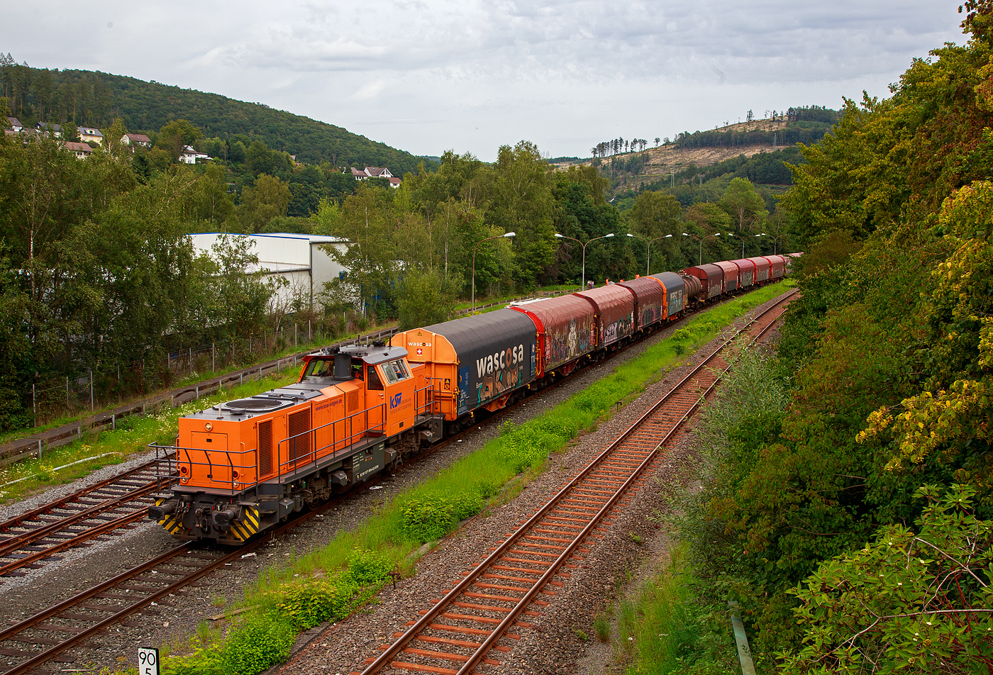 Die KSW 44 (92 80 1271 004-4 D-KSW) eine MaK G 1000 BB der KSW (Kreisbahn Siegen-Wittgenstein), steht am 24.08.2023 mit einem Übergabezug (leere Wagen), auf ihren Rangierbahnhof in Herdorf der Betriebsstätte FGE -Freien Grunder Eisenbahn (KSW NE447 / DB-Nr. 9275), zur Abfahrt bereit. Aber noch muss sie den Gegenverkehr abwarten, bevor sie in Richtung Betzdorf losfahren kann.

Rechts die eingleisige DB Strecke KBS 462 „Hellertalbahn“ (Betzdorf – Herdorf – Haiger).