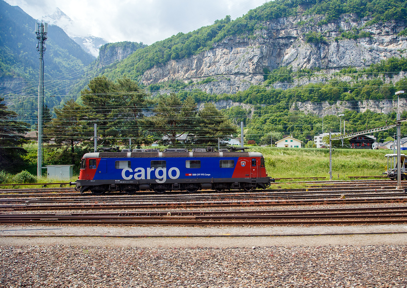 Die Re 620 021-6 “Taverne-Torricella“ (91 85 4620 021-6 CH-SBBC) der SBB Cargo AG, ex SBB Re 6/6 – 11621, ist am 28.05.2023 beim Bahnhof St-Maurice abgestellt, aufgenommen aus dem Zug heraus.

Die Re 6/6 wurde 1976 von der SLM in Winterthur (Schweizerische Lokomotiv- und Maschinenfabrik) unter der Fabriknummer 5008 gebaut, der elektrische Teil ist von BBC. Führerstands-Klimaanlagen wurden nachträglich eingebaut.