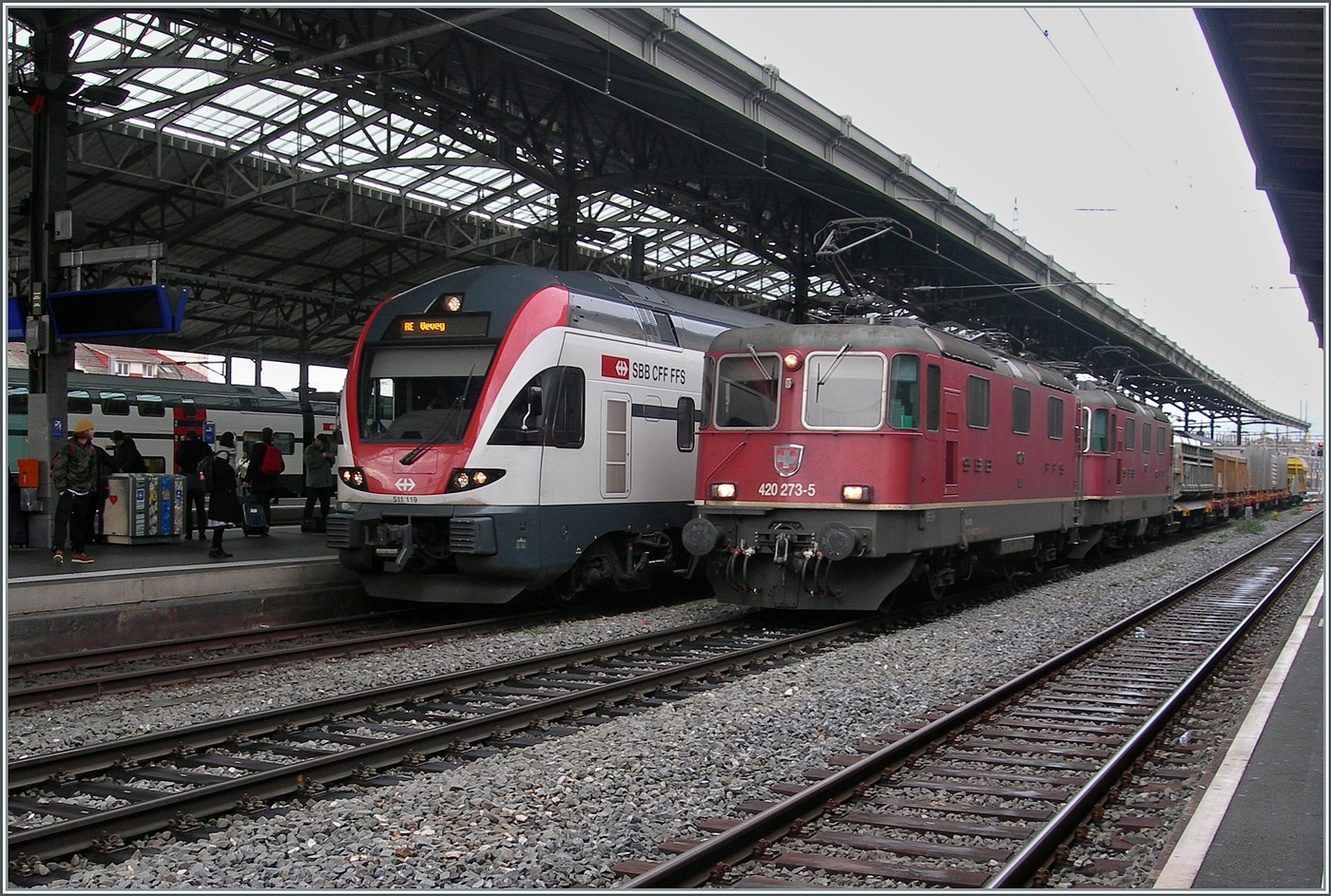 Die SBB Re 4/4 II 11273 (Re 420 273-5) und Re 4/4 II 11269 (Re 420 269-3) in Vielfachsteuerung warten mit ihrem Güterzug in Lausanne die Überholung mit dem RABe 511 119 ab, um dann ihre Fahrt in Richtung Villeneuve fortzusetzten. 

2. Dez. 2024