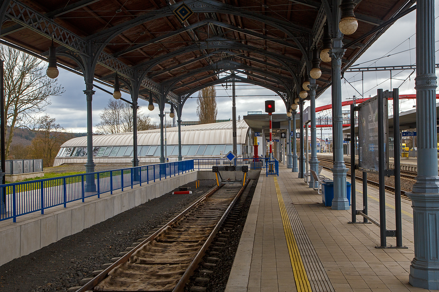 Die sehr schöne denkmalgeschützte Bahnsteigüberdachung vom Kopfgleis 1 vom Bahnhof Karlovy Vary (Horním nádražím) / Karlsbad (Oberer Bahnhof), hier am 17.04.2023. Sie ist das letzte Überbleibsel aus alten Zeiten,

Im Jahr 1945 wurden beide großen Karlsbader Bahnhöfe Ziel alliierter Bombenangriffe. So wurde das ursprüngliche Empfangsgebäude durch die Bombenangriffe alliierter Truppen im Zweiten Weltkrieg durch zerstört. Bereits 1945 wurde mit der Errichtung eines Ersatzgebäudes mit Hilfe von Freiwilligen begonnen. Das Provisorium blieb nach leichten baulichen Veränderungen bis zum Beginn der Modernisierung im Jahr 2015 bestehen.