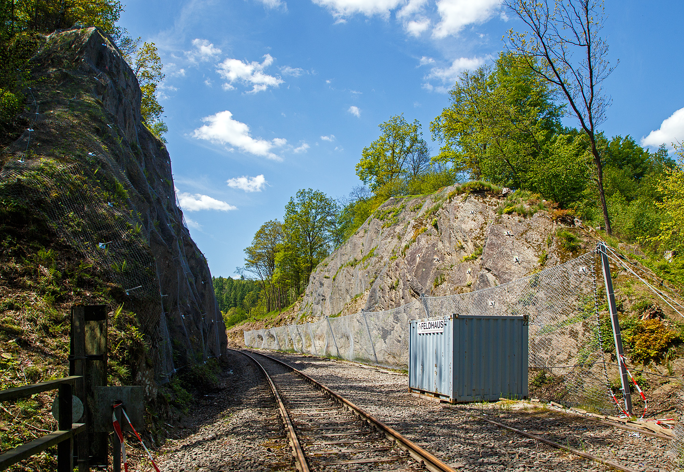 Die Strecke der Hellertalbahn (KBS 462), von Herdorf gesehen hinter dem Hp  Königsstollen am 19.05.2023, nun sind auch links die Netze zur Hangsicherung montiert. Die rechte Seite, wo inaktive zweite Gleis liegt, war schon lange montiert. Nur leider gab es am 23.12.2022 einen Erdrutsch auf der linken Seite und ein Triebwagen entgleiste. Verletzt wurde zum Glück niemand.