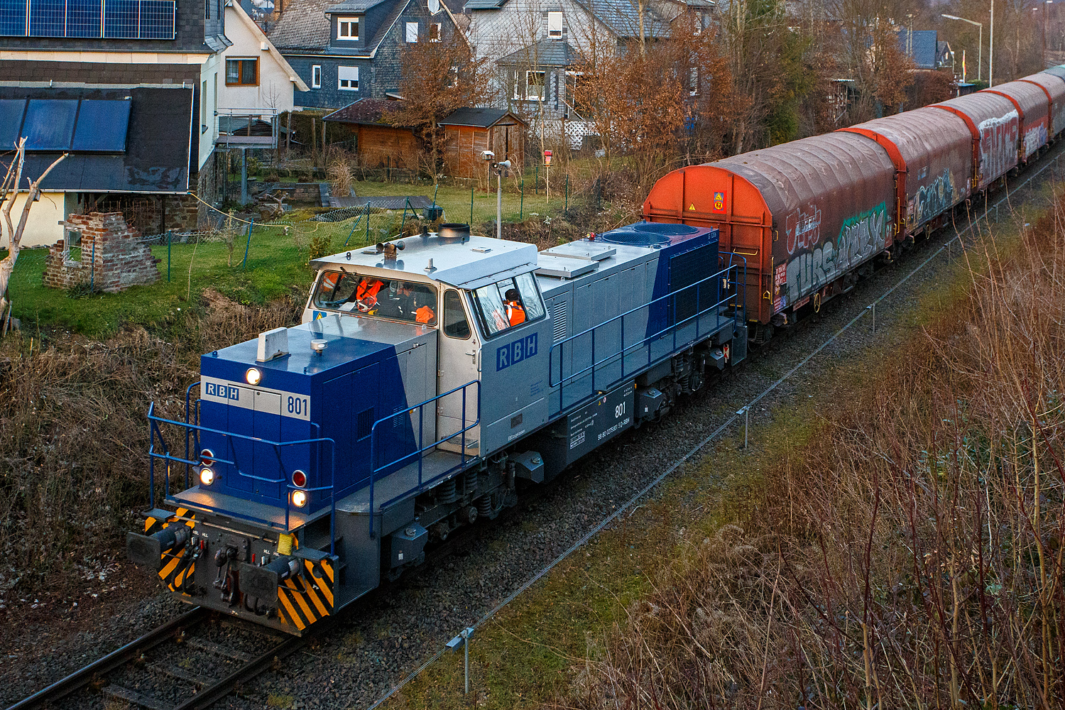 Die zurzeit an die KSW (Kreisbahn Siegen-Wittgenstein) vermietete RBH 801 / 275 801-5 (98 80 0275 801-5 D-RBH), eine MaK G 1206 der RBH - RAG Bahn und Hafen GmbH (Gladbeck), fährt am 26 Februar 2026, mit einem Übergabegüterzug (leere Wagen), von Herdorf via Betzdorf nach Kreuztal.

Die MaK G 1206 wurde 1997 von der Siemens Schienenfahrzeugtechnik (SFT) in Kiel-Friedrichsort unter der Fabriknummer 1000900 gebaut und an die damalige RAG - Ruhrkohle AG, RAG Bahn- und Hafenbetriebe in Gladbeck als RAG 802 ausgeliefert. Sie war die erste gebaute Lok des erfolgreichen Typs G 1206 aus dem 3. Typenprogramm. Im Jahr 2004 erfolgte die Umfirmierung der RAG in RAG Bahn und Hafen GmbH (RBH) und nach der Übernahme durch die DB Schenker Rail Deutschland AG (heute DB Cargo) erfolgte 2006 die Umfirmierung in RBH Logistics GmbH.