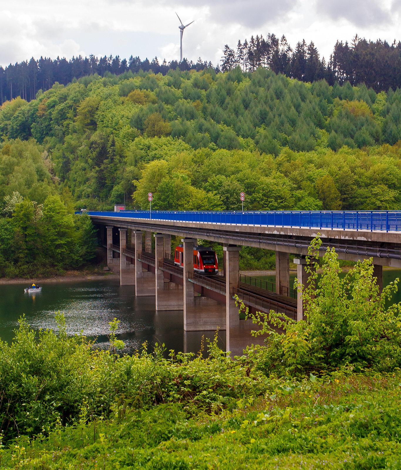 Ein Alstom Coradia LINT 27 der DreiLänderBahn (DB Regio) überquert am 12 Mai 2013, als Regionalbahn RB 92  Biggesee-Express , den Biggesee auf der Doppelstockbrücke Dumicketal bei km 16,6 der Bahnstrecke KBS 442  Biggetalbahn  (Finnentrop - Olpe – [Freudenberg]).

Die KBS 442 (Finnentrop–Olpe) ist eine 23,6 km lange eingleisige, nicht elektrifizierte Nebenbahn, die bis 1983 noch 20 km weiter bis Freudenberg (Kr. Siegen) ging, mit weiterem Anschluss über die auch stillgelegte Asdorftalbahn nach Betzdorf.

Die Doppelstockbrücke Dumicketal:
1956 begannen die Planungsarbeiten für die Biggetalsperre. Die Bauarbeiten begannen 1958. Dadurch bedingt war eine  Neubaustrecke  notwendig, da die alte Strecke mehrere Meter unter Wasser stehen würde. So entstanden auch die beiden Doppelstockbrücken Dumicketal und Listertal über die Biggetalsperre, jeweils oberen Ebene Straße und auf der darunter liegenden Ebene die eingleisige Bahnstrecke. Die beiden Doppelstockbrücken, Dumicketal und Listertal, sind baugleich und unterseiden sich in ihrer Länge.

Im Verlauf der Landesstraße L 512 und der Bahnstrecke Attendorn – Olpe der Deutschen Bundesbahn wurde 1963 bei Sondern diese 282,25 Meter lange Talbrücke über die, damals im Bau befindliche, Biggetalsperre errichtet. Auf der Doppelstockbrücke werden sowohl die Landesstraße als auch die eingleisige Bahnstrecke geführt, deren Schienen unmittelbar vor und nach der Brücke in einen Tunnel münden. Die Stützweiten der neunfeldrigen Dumicketalbrücke betragen einheitlich etwa 31,4 Meter, die Gesamtbreite der Straßenbrücke beträgt etwa 14 Meter. Der Spannbetonüberbau der Straßenbrücke besteht aus einem zweistegigen Plattenbalken. Die stählerne Bahntrasse wurde unter dem Überbau der Straßenbrücke auf den Pfeilern aufgelagert. Die Baukosten der Dumicketalbrücke beliefen sich auf ca. 2 Millionen Deutsche Mark. 2003-2004 wurde der Überbau der Straßenbrücke mit extern geführten Spanngliedern des Typs VT-CMM verstärkt, um die Tragfähigkeit der Brücke zu erhöhen.

Rechtzeitig zum Staubeginn 1965 wurde die „neue“ Bahnstrecke in Betrieb genommen.

