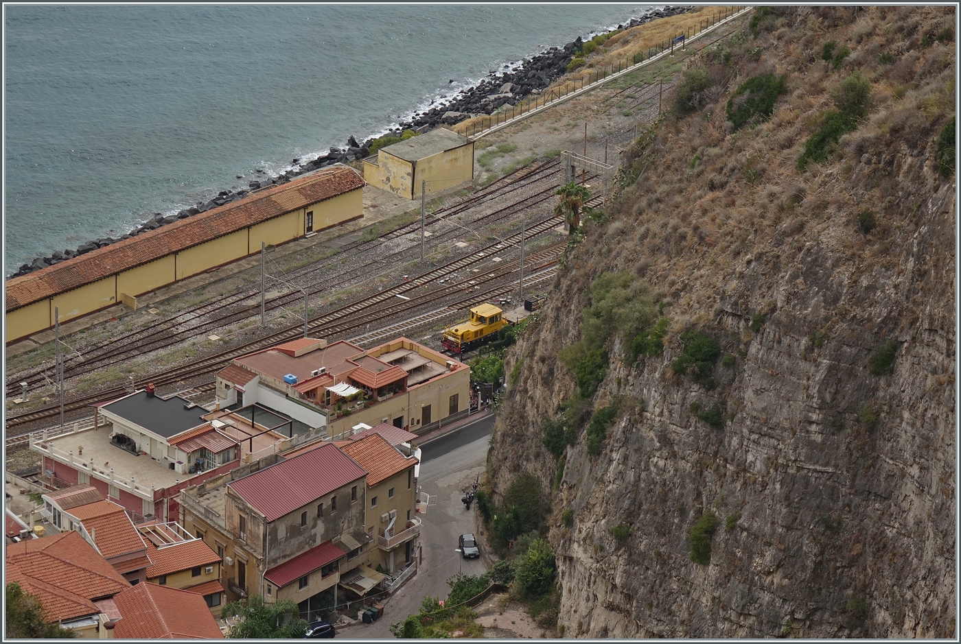 Ein Blick auf den Bahnhof Taormina Gardini vom hoch gelegenen Taormina aus: im nördliche Bahnhofskopf zeigt sich RFI Baudienstfahrzeug im Bahnhof von Taormina-Giardini.

24. Sept. 2025