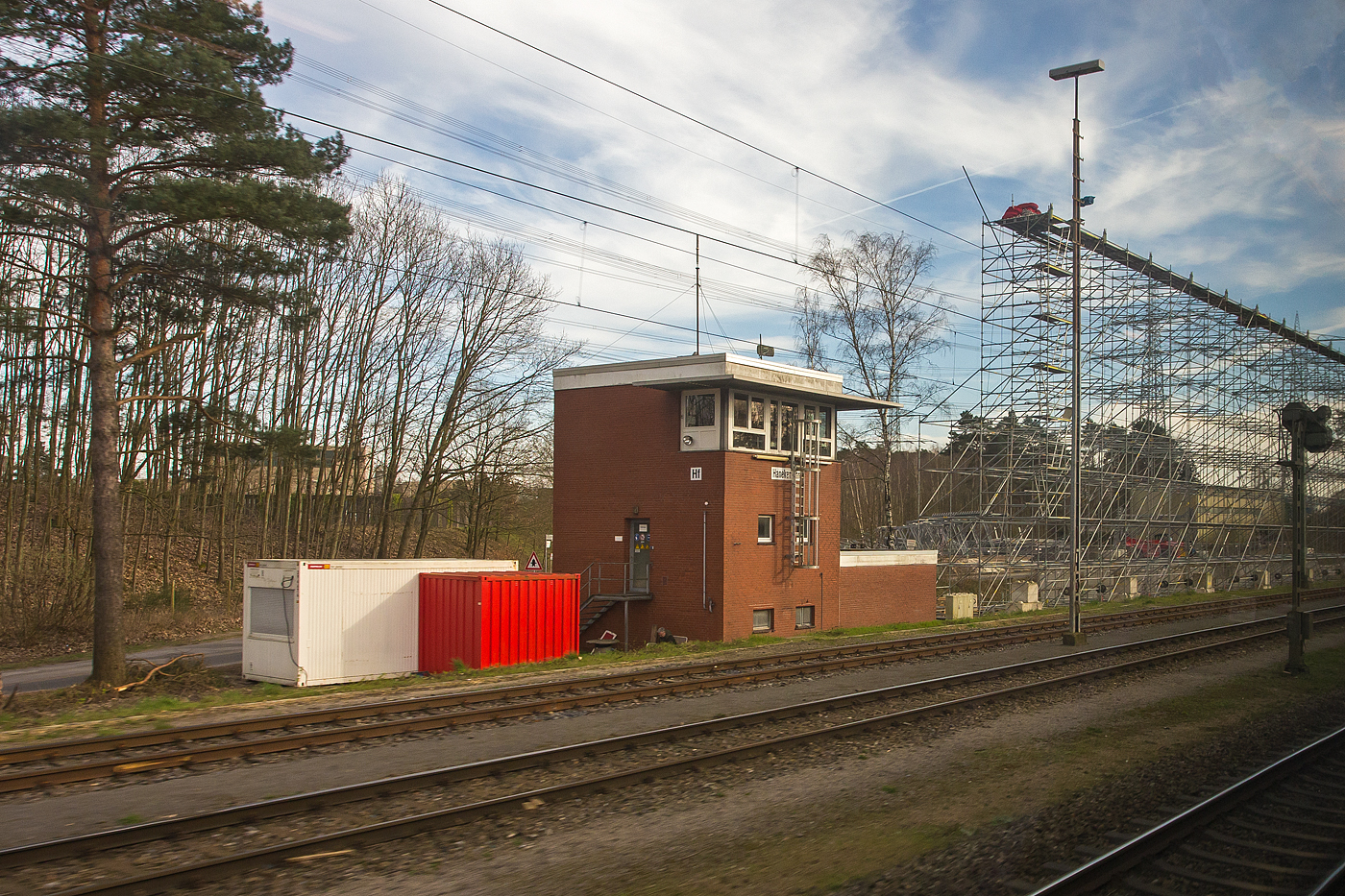 Ein Blick aus dem Zug auf das elektromechanische Stellwerk Hanekenf�hr Fahrdienstleiter „Hf“ am 14 M�rz 2024. Das aktive Stellwerk ist in der Bauform VES 1912 (E43) mit Gl�hlampen�berwachung. 

Das Stellwerk Hanekenf�hr befindet sich s�dlich von Lingen an der Emslandstrecke KBS 395 Rheine - Emden – (Norddeich Mole) und liegt zwischen den ehemaligen Kernkraftwerken Lingen und Emsland.
