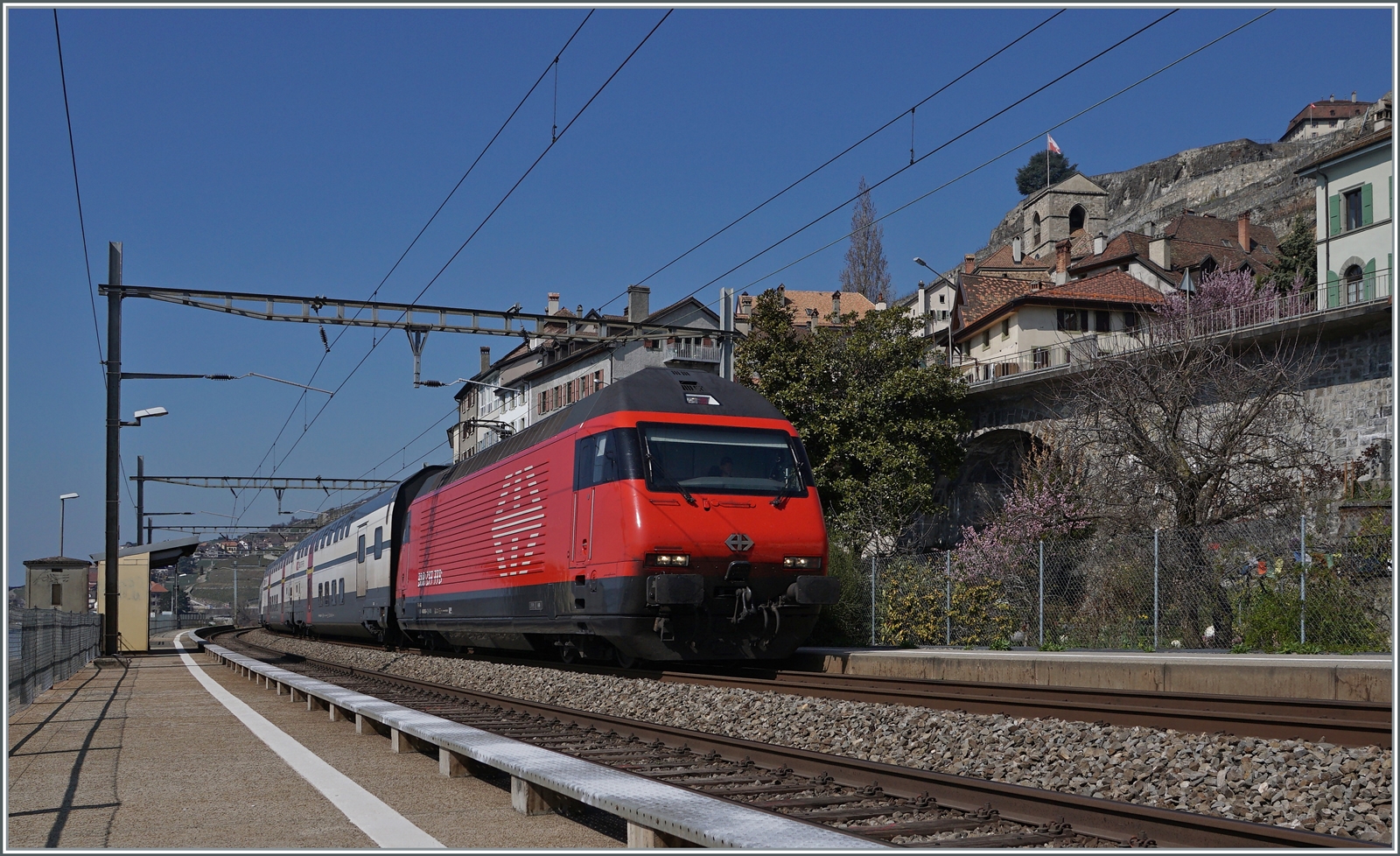 Eine SBB Re 460 ist mit ihrem IR 90 bei St-Saphorin auf dem Weg nach Brig.

25. März 2022