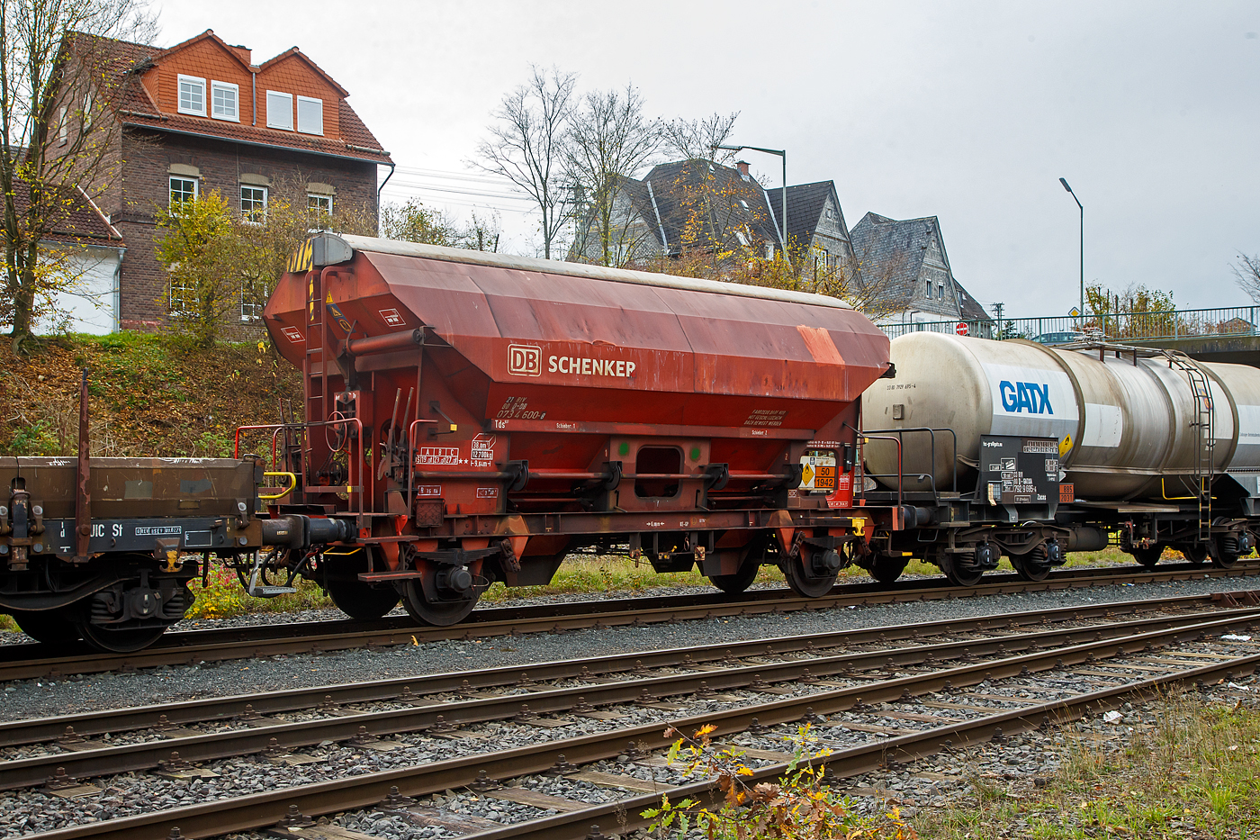 Gedeckter Schüttgutwagen mit dosierbarer Schwerkraftentladung und zwei Radsätzen 21 80 0734 600-8 D-DB, der Gattung Tds 937, der DB Cargo AG abgestellt, im Zugverband eines Übergabezuges der KSW, am 03.11.2022 in Herdorf auf dem Rbf. der KSW.

In diesen Wagen wird Ammoniumnitrat (Gefahrgutnummer 50/1942) zur Sprengstoff Herstellung zur Fa. Dynamit Nobel Defence nach Burbach-Würgendorf gefahren (hier ist er leer).  Ammoniumnitrat ist der Stoff  von dem ca. 2.750 Tonnen im Hafen von Beirut am 4. August 2020 explodierten und zur der bekannten gewaltigen Explosionskatastrophe führten.

Der Wagen trägt außerdem einen Aufkleber der Firma YARA Rostock, das zum norwegischen Konzern Yara International gehört. Yara ist ein Hersteller und Anbieter von Chemikalien und Industriegasen wie Dünger, Harnstoff, Nitraten und Ammoniak. Das Unternehmen entstand 2004 durch Abtrennung vom Unternehmen Hydro Agri, einem Firmenbereich von Norsk Hydro.

Die Wagen besitzen eine gleisseitige, dosierbare Entladeeinrichtung. Ein Innenanstrich erhöht bei den meisten der Fahrzeuge den Gebrauchswert, insbesondere durch den Schutz vor Verunreinigungen, Möglichkeiten des Transportes von Lebensmitteln, günstigeres Entladeverhalten (Rutschverhalten) bei schwer fließenden Gütern sowie durch verbesserten Korrosionsschutz bei aggressiven Ladegütern.

Der Wagen ist für den Transport von nässeempfindlichen Schüttgütern aller Art, wie z. B. Salze und Düngemittel, vorgesehen. Sie besitzen eine gleisseitige, dosierbare Entladeeinrichtung. Ein Innenanstrich erhöht bei den meisten der Fahrzeuge den Gebrauchswert, insbesondere durch den Schutz vor Verunreinigungen, Möglichkeiten des Transportes von Lebensmitteln, günstigeres Entladeverhalten (Rutschverhalten) bei schwer fließenden Gütern sowie durch verbesserten Korrosionsschutz bei aggressiven Ladegütern. Der Transport grobkörniger oder kantiger, schwerer Güter (z. B. Kies, Schlacke, Schotter) ist wegen einer möglichen Beschädigung der Innenbeschichtung nicht zulässig.

Das Untergestell und der Wagenkasten sind als Schweißkonstruktion unter Verwendung von Walzprofilen und Blechen hergestellt. Beide Teile sind miteinander verschweißt. Der Wagen besitzt zwei Bühnen, die von beiden Seiten zugänglich sind. Beide Bühnen sind mit einer Sprossenleiter versehen. Die Arbeitsbühne ist mit Handhebeln zur Betätigung der Wölbschieber, mit dem Handrad zur Öffnung des Daches und teilweise mit einer Feststellbremse und Notbremshahn ausgerüstet. Der Neigungsgrad des trichterförmigen Wagenkastens ermöglicht eine restlose selbsttätige Entladung. Die Entladung des Wagens erfolgt über Wölbschieber. Der Wagen ist mit einem einschaligen Hubschwenkdach ausgerüstet. Das Dach wird vor dem Schwenken angehoben und dann seitlich abgeschwenkt, wobei die gesamte Breite der Beladeöffnung freigegeben wird. Im geschlossenen Zustand ist das Dach gegen unbeabsichtigtes Verschwenken gesichert.

TECHNISCHE DATEN:
Spurweite: 1.435 mm
Achsanzahl: 2
Länge über Puffer: 9.640 mm
Achsabstand: 6.000 mm
Laufraddurchmesser: 1.000 mm (neu)
Wagenhöhe: 4.198mm
Größe der Beladeöffnung Länge x Breite: 8.000 x 1.200 mm
Laderaum: 38 m³
Eigengewicht: 12.700 kg
Höchstgeschwindigkeit: 100 km/h (beladen) / 120 km/h (leer)
Maximales Ladegewicht: 27,0 t  ab Streckenklasse C
Kleinster bef. Gleisbogenradius: 35 m
Bauart der Bremse: KE-GP (LL)
Bremssohle: IB 116
Intern. Verwendungsfähigkeit: RIV

Auch in dem Kesselwagen davor 33 80 7929 695-4 D-GATXD, der Gattung Zacns, wurde ein Rohstoff für die Herstellung von Sprengstoffen transportiert und zwar Salpetersäure.