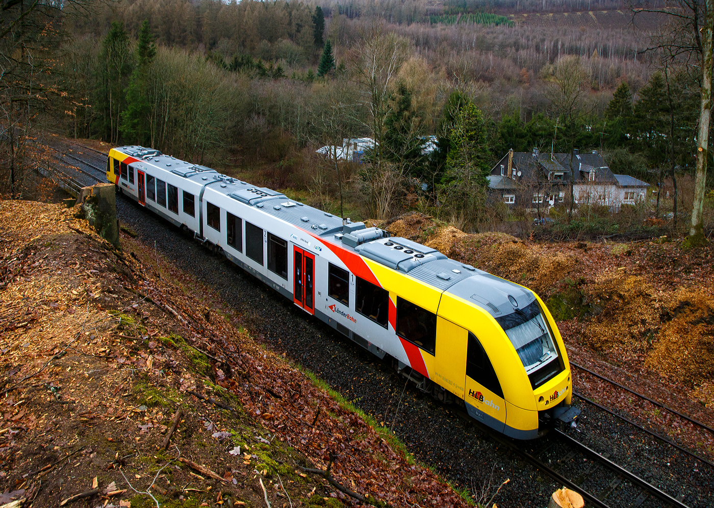Glück im Unglück.....
Herdorf den 23. Dezember 2022 ca. 18:15 Uhr (Bild vom 24.12.)
Zug entgleist in Herdorf kurz hinter dem Hp  Königsstollen (bei km 88,4) – Fahrgäste kommen mit dem Schrecken davon. Wie sich kurze Zeit später herausstellte hatte ein Erdrutsch dazu geführt. Hier im Bild der havarierte Triebwagen VT 507.
	
Der Diesel-Triebwagen VT 507 (95 80 1648 107-8 D-HEB / 95 80 1648 607-7 D-HEB), ein Alstom Coradia LINT 41 der neuen Generation, der HLB (Hessische Landesbahn GmbH), war am 23.12.2022 (Bf Herdorf ab 18:10 Uhr), als RB 96  Hellertalbahn  Neunkirchen - Herdorf - Betzdorf (Umlauf 61790) von Herdorf nach Betzdorf unterwegs. Kurz hinter dem Hp Königsstollen (bei km 88,4) kam es zu einen Erdrutsch zum Teil mit Felsbrocken, als gerade der Triebwagen die Stelle passierte, entgleiste das vorderen Drehgestell. Der Triebwagen mit Passagieren ist im Gleisbett geblieben und nach ca. 100 m er an der Eisenbahnbrücke, die über die Landesstraße führt, zum Stehen. Die ca. 15 Fahrgästen und der Treibfahrzeugführer kamen Dankbarerweise nicht zu Schaden. Da der Hp  Königsstollen ein Bedarfshalt ist, reduziert (wenn er nicht gehalten hat) der Treibfahrzeugführer zum Glück eh die Geschwindigkeit, in voller Fahrt hätte es anders ausgehen können.

Der Treibfahrzeugführer erklärte den Fahrgästen die Situation. Kurze Zeit später trafen die Rettungskräfte ein. Dank einer als provisorische Treppe umfunktionierten Steckleiter, an der Böschung am Wiederlager der Brücke, konnten Feuerwehrleute die Fahrgäste innerhalb von 15 Minuten wohlbehalten nach unten zur Landesstraße geleiten.

Die Polizei gibt als Ursache für den Erdrutsch die Witterungsbedingen an. Die Strecke bleibt bis mindestens Dienstag 27.12.2022 gesperrt sein, weil ein Spezialzug zur Bergung benötigt wird. Neben Erdreich sind auch massive Felsbrocken infolge des Hangrutsches auf dem Gleisbett gelandet, diese müssen auch erst weggeräumt werden, dafür braucht man auch Großgerät und über die Feiertage muss man auch erstmal noch eine Firma bekommen.

Im Einsatz waren neben dem Rettungsdienst und Polizei 40 Kräfte der Löschzüge Herdorf, Sassenroth und Daaden. Die anliegende Landesstraße musste aufgrund der eingesetzten Rettungskräfte ebenfalls voll gesperrt werden. Die Ermittlungen wurden von der zuständigen Bundespolizei übernommen.

Interessant ist die Tatsache das auf der einen Seite vom Gleis bereits umfangreiche Hangsicherungsmaßnahmen stattgefunden haben. Und die andere Seite noch nicht gesichert war.

Quellen: Rhein Zeitung, DPA und eigene Recherchen

Link zum Artikel der Rhein Zeitung:
http://www.rhein-zeitung.de/region/aus-den-lokalredaktionen/kreis-altenkirchen_artikel,-zug-entgleist-bei-herdorf-fahrgaeste-kommen-mit-dem-schrecken-davon-_arid,2486964.html
