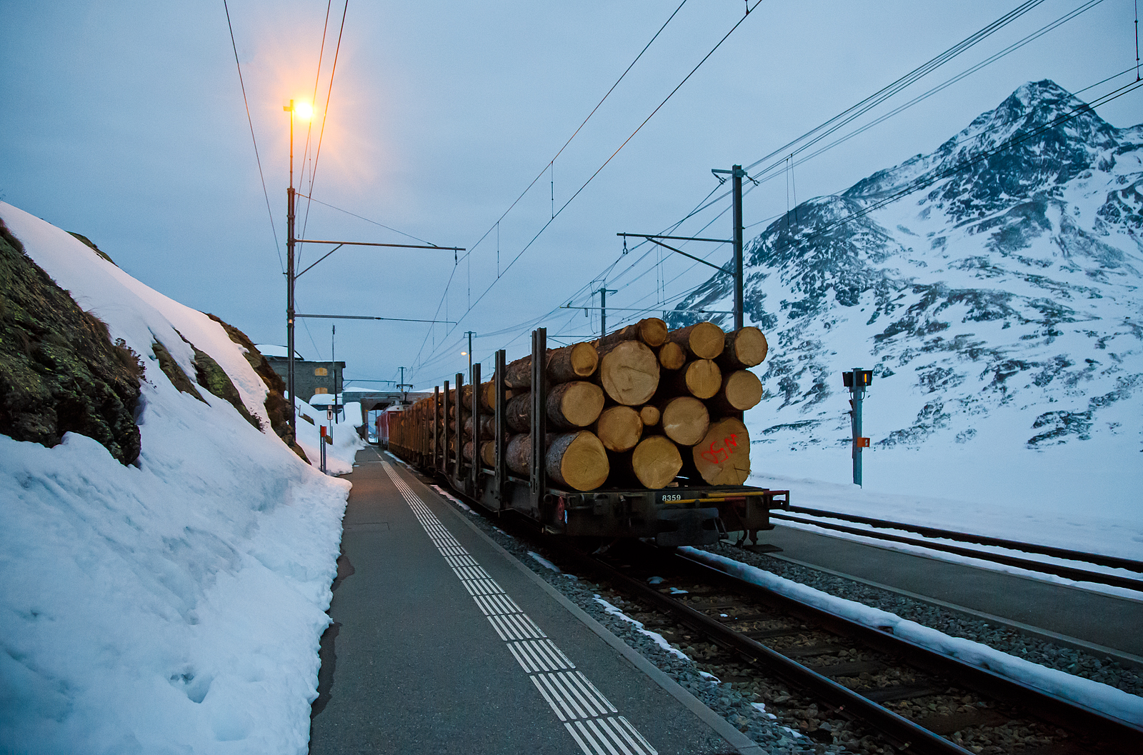 Nun haben die beiden RhB ABe 4/4 III Triebwagen 54  Hakone  und  51  Poschiavo  am 21.03.2023 als PmG (Personenzug mit G�terbef�rderung) nach Poschiavo, fahren nun vom h�chsten Punkt der Berninabahn, den Bahnhof Ospizio Bernina weiter nach Poschiavo.

Ab hier sind nun eher die Bremsen gefordert, denn nun geht es bis nach Poschiavo fast nur bergab. Von Pontresina nach Ospizio Bernina geht es nur bergauf, und wir merkten wie die Triebwagen arbeiten mussten.