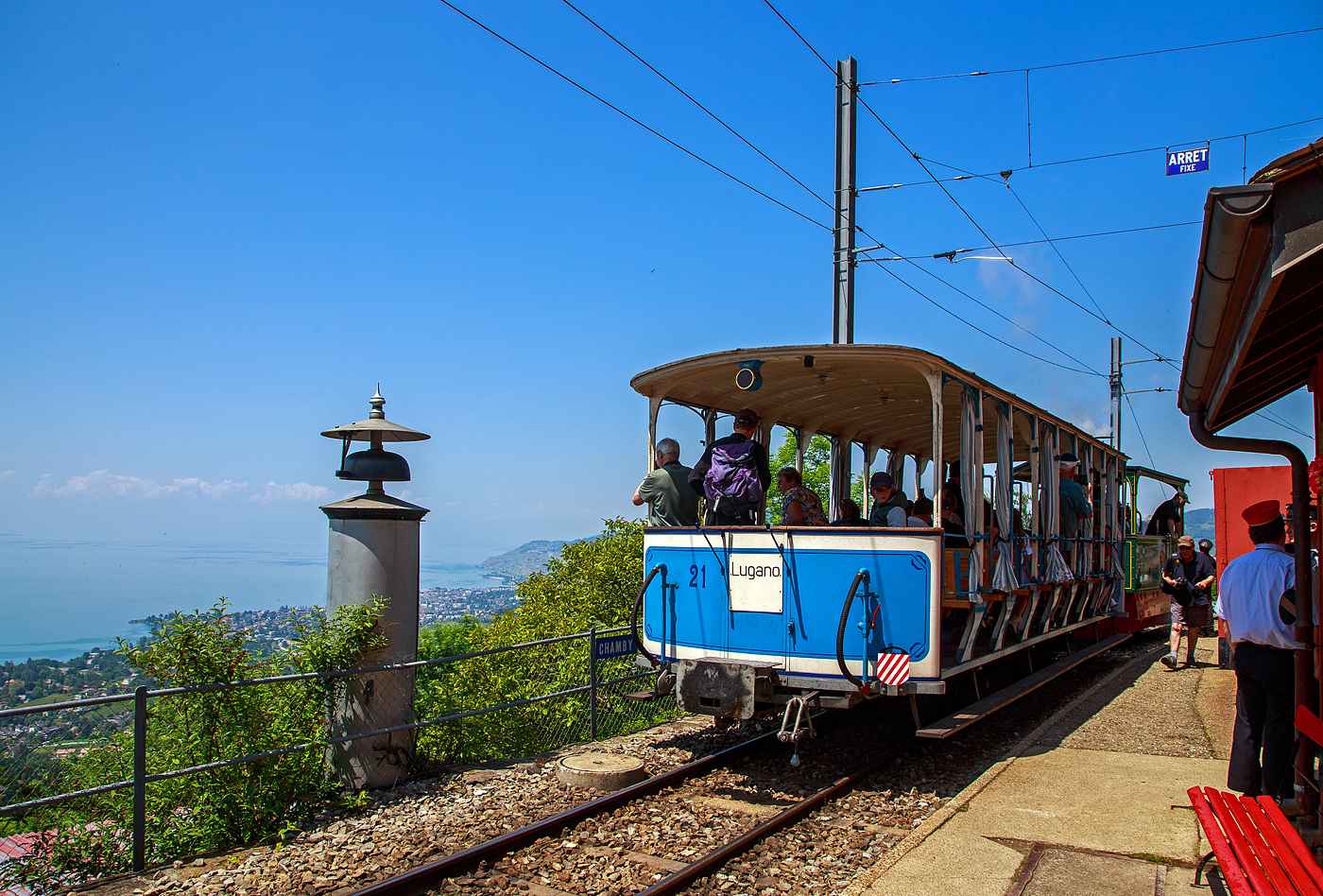 Pfingsten 2023 (Samstag 27. bis Montag 29. Mai 2023) fand bei der Museumsbahn Blonay–Chamby das Schweizer Dampffestival 2023 / Festival suisse de la Vapeur 2023 statt.

Bahnhof Chamby �ber dem Genfersee am 27. Mai 2023, die G 2/2 Nr. 4 (020T) Krauss-Kastendampflok (Tramlok), ex Rimini-Novalfeltria (I), der Museumsbahn Blonay–Chamby, hat gerade mit dem vorgestellten zweiachsigen haboffenen Personenwagen (Sommerwagen) ex LCD C 21 den Bahnhof erreicht. 

Links ein L�utewerk, der Zug steht auf der Strecke (KBS 115) Blonay–Chamby, sie wird in der Sommersaison von der Museumsbahn BC betrieben und befahren, geh�rt aber der Transports Montreux–Vevey–Riviera (MVR, ex CEV). 

Der LCD C2 21 mit dem Spitznamen Giardiniera (Gartenhaus) ist einer der beiden urspr�nglichen erhaltenen aber unterschiedlichen zweiachsigen Personenwagen der Lugano-Cadro-Dino-Bahn. Er charakterisiert sich durch die offene Bauweise als Sommerwagen mit durchgehenden in der Fahrtrichtung umlegbaren R�cklehnen der Holzb�nken, im Gegensatz zum C2 11, bei dem es sich um einen geschlossenen Personenwagen mit festen Sitzb�nken handelt.

Die von Anfang an elektrisch betriebene Lugano-Cadro-Dino-Bahn, abgek�rzt LCD, hatte bei ihrer Betriebser�ffnung 1911 gerade sieben Fahrzeuge, vier baugleiche Triebwagen und drei unterschiedliche Personen- und G�terwagen.1943 wurden zwei zus�tzliche Sitzb�nke auf den damals noch offenen Endplattformen eingef�gt und damit die Anzahl Sitzpl�tze erh�ht. Im Zusammenhang mit der Klassenreform 1956 wurde der Sommerwagen neu als zum B2 21 bezeichnet.

W�hrend in den L�ndern des S�dens viele Bahnen offene Fahrzeuge einsetzen, sind diese Fahrzeuge in unseren Breiten doch seltener. Neben der Basler Tram war die Lugano-Cadro-Dino-Bahn (LCD) eine der wenigen in der Schweiz, die solche Fahrzeuge einsetzte. 

Der hier vorgestellte Wagen mit dem Spitznamen „Giardiniera“ (Gartenhaus) ist prominent auf den Werbeprospekten dieser ehemaligen Bahn zu finden. An den Wochenenden nehmen viele Stadtbewohner ihre Pl�tze an Bord ein und genie�en die herrliche Aussicht auf den Luganersee, vorbei an Weinbergen und Kastanienw�ldern.Von einer touristischen Berufung in den Kinderschuhen hat sich die Eisenbahn im Laufe der Jahre im Zuge ihrer Entwicklung zu einem Vorortdienst entwickelt. Da es immer h�ufiger zu Konflikten mit dem Autoverkehr kam, wurde der st�dtische Endpunkt der Bahn 1967 vor die Tore der Stadt verlegt. Nachdem dieser Abschnitt, der ihn mit dem Stadtzentrum und der Anlegestelle verband, abgetrennt wurde, nahm seine touristische Attraktivit�t stark ab, was im Juni 1970 dazu f�hrte, dass die Eisenbahn durch eine Busverbindung ersetzt wurde. Die „Giardiniera“ wurde auf dem Platz des alten Bahnhofs von Tesserete, in Erinnerung an andere Tessiner Eisenbahnen, die zur gleichen Zeit verschwanden, als Denkmal abgestellt. Aber st�ndig dem Wetter ausgesetzt, sind kostspielige Wartungsarbeiten erforderlich, um es in einem gutem Zustand zu erhalten.Aus Sorge um seinen Erhalt verkaufte das Unternehmen Autolinee Regionali Luganesi, der neue Betreiber der ehemaligen Eisenbahnverbindungen der Region, diesen Wagen im Dezember 1990 an Blonay-Chamby. Er wurde dann einer umfassenden �berholung unterzogen. Die Achsen, der Boden, die Pfosten, B�nke und ihre schmiedeeisernen St�tzen, Sicherheitsbarrieren und das gesamte Blech wurden erneuert, sodass der Wagen „Giardiniera“ im Sommer 1995 seien Betrieb, mit der urspr�nglichen Bezeichnung, wieder aufnehmen konnte. Der Wagen ist mit der urspr�nglichen Mittelpufferkupplung, sowie zus�tzlich zur Vakuumbremse mit einer Druckluftbremse versehen. 2011, anl�sslich des hundertj�hrigen Bestehens des Wagens, wurde er wieder mit dem urspr�nglichen Anstrich versehen.

TECHNISCHE DATEN:
Baujahr: 1911
Hersteller: SWS Schlieren (Schweizerische Wagons- und Aufz�gefabrik AG)
Spurweite: 1.000 mm (Meterspur)
Achsanzahl: 2 
Eigengewicht: 5,1 t
Sitzpl�tze: 50 in der 3. Klasse
