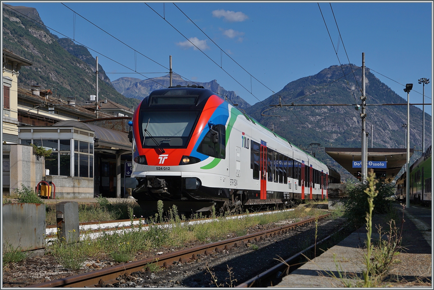TILO Flirts RABe 524 gehören seit einigen Jahren auf Treniatlia- oder Trenordstrecken zum alltäglichen Betriebsgeschehen. Aber ein TILO Flirt im Piemont, genauer gesagt in Domodossola, ist dann doch eine Seltenheit. Der SBB TILO RABe 524 102 (UIC 94 85 0 524 012-7 CH-FFS) nun mit einem gehoben Stromabnehmer in den Gleichstromteil des Bahnhofs von Domodossola. Allem Anschein nach ist der Triebwagenzug auf Probefahrt. 

22. August 2025 