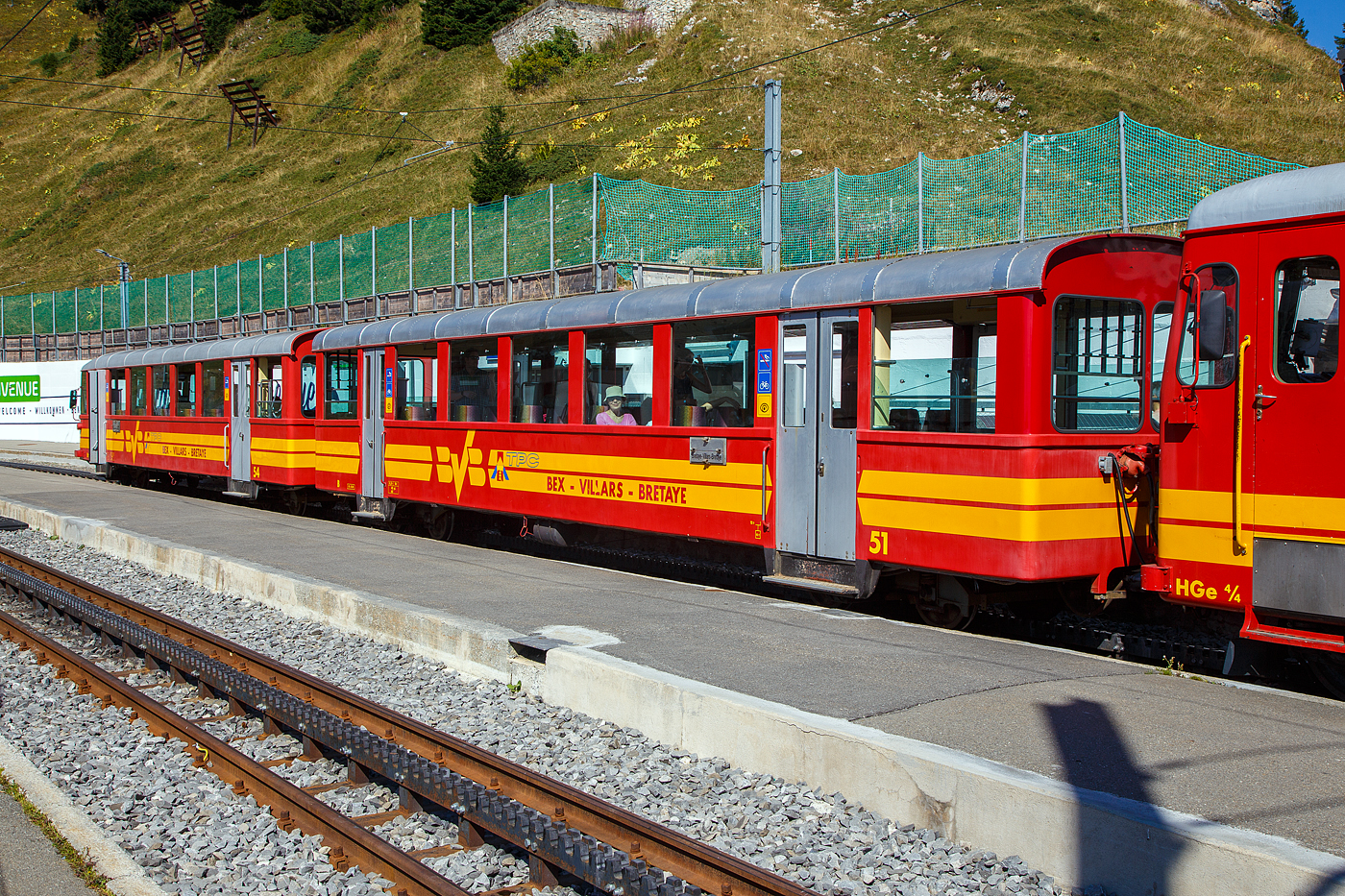 Vor der tpc BVB HGe 4/4 32 „Villars“ am 10 September 2023 im Bergbahnhof Col-de-Bretaye (1.808 m ü. M.), eingereiht in einen Personenzug, der Steuerwagen tpc BVB Bt 54 und der Personenwagen tpc BVB B 51.

Die vierachsigen Wagen wurden 1953 von der SIG (Schweizerische Industrie-Gesellschaft) in Neuhausen am Rheinfall gebaut, die Elektrik ist von der MFO (Maschinenfabrik Oerlikon).

Heute sind diese Garnituren nicht mehr im Planeinsatz. Hier an dem Wochenende (08 bis 10 September 2023) feiert die TPC 125 Jahre BVB! (Les TPC célèbrent les 125 ans du BVB!). So kamen auch historische Züge und Triebwagen zum Einsatz.
