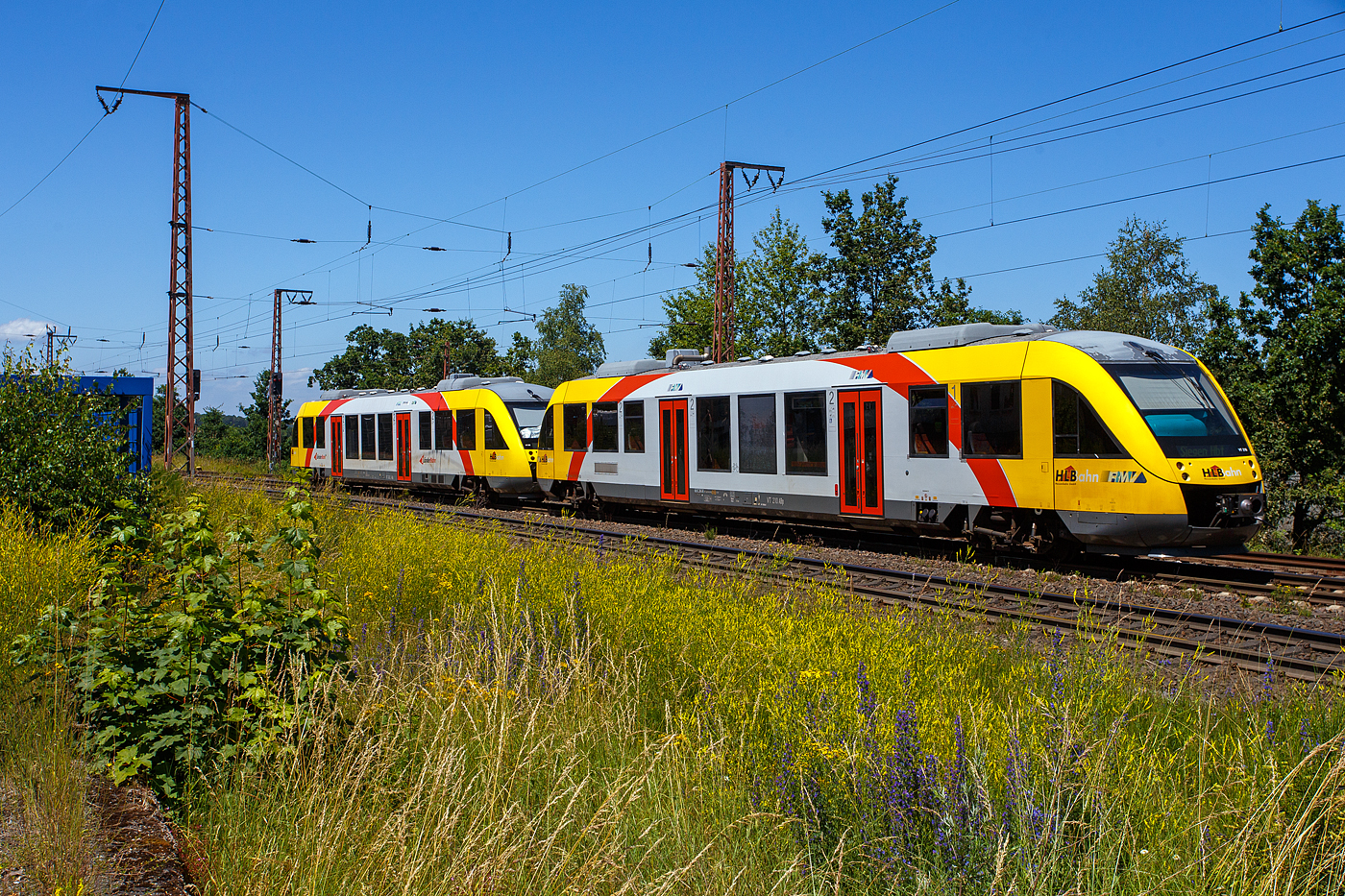 Zwei gekuppelte Dieseltriebzüge vom Typ Alstom Coradia LINT 27, der HLB (Hessische Landesbahn GmbH), verlassen am 28 Juni 2024, als RB 95  Sieg-Dill-Bahn  (Dillenburg – Siegen) den Hp Wilnsdorf-Rudersdorf (Kr. Siegen) und fahren weiter nach Siegen Hbf, welches auch der nächste und letzte Halt ist.

Vorne der VT 202 ABp (95 80 0640 102-9 D-HEB) und dahinter der VT 210 ABp (95 80 0640 110-2 D-HEB). Beide Alstom Coradia LINT 27 wurde 2004 von Alstom (vormals Linke-Hofmann-Busch GmbH (LHB) in Salzgitter-Watenstedt gebaut und an die vectus Verkehrsgesellschaft mbH, mit dem Fahrplanwechsel am 14.12.2014 wurden alle Fahrzeuge der vectus nun Eigentum der HLB. Der VT 202 wurde unter der Fabriknummer 1187-002 und der VT 210 unter der Fabriknummer 1187-010 gebaut.