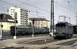 144 076-5 setzt in Pforzheim um; im Bahnhofsbereich steht 144 035-3 mit Umbauwagen und wartet auf den Einsatz, am 1704.1982.