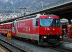 Die RhB Ge 4/4 III – 651  Fideris  mit Werbung f�r den Glacier Express ( Glacier on Tour“) steht am 18.02.2017 im Bahnhof Chur mit dem RegioExpress nach St. Moritz zur Abfahrt bereit. Wir fuhren bis Samedan mit, aber zuvor musste ich schnell noch dieses Bild machen.

Durch das ansteigende Verkehrsaufkommen war die Rh�tische Bahn (RhB) veranlasst Ende der 1980er Jahre ein Konzept f�r eine neue Lokomotivgeneration zu erstellen. Gemeinsam mit SLM und ABB entwickelte die Rh�tische Bahn eine Lok, deren Antrieb auf der Drehstromtechnik mit GTO-Thyristoren basiert. Die neuen Lokomotiven sollten in der Lage sein, Personen- und G�terz�ge auf dem Stammnetz, aber auch Autotransportz�ge durch den neuen Vereinatunnel zu ziehen. Wobei f�r den Einsatz im Vereinatunnel eine sechsachsige Lok die ideale Wahl gewesen w�re, wurde entschieden, vierachsige Fahrzeuge zu bestellen. Da die vierachsigen Loks f�r die F�hrung von Z�gen auf den kurvenreichen Strecken des Stammnetzes, wie beispielsweise der Albulalinie, geeigneter sind.

Neben den modernen GTO-Stromrichtern haben die Lokomotiven neu entwickelte Drehgestelle mit selbst�ndig radial einstellenden Rads�tzen, dadurch wird der Verschlei� zwischen Rad und Schiene vermindert.

1989 bestellte die RhB sechs und 1991 weitere drei Lokn bei der Schweizer Industrie. Die Biere - Apples - Morges Bahn (BAM) schloss sich 1990 dieser Bestellung mit zwei Fahrzeugen f�r die Bef�rderung schwerer Panzerz�ge an. Vier weitere Lokomotiven wurden unter Verwendung �hnlicher mechanischer Komponenten f�r die MOB gebaut. Der elektrische Teil der MOB Lokomotiven hingegen ist eine komplette Neuentwicklung. P�nktlich zur Er�ffnung des Vereina-Tunnels wurden von der RhB Ende 1999 drei weitere Lokomotiven in Betrieb genommen. 

Ein modernes und funktionelles Design wurde f�r die Gestaltung von dem Lokomotivkasten gew�hlt. Die Antriebseinheit besteht aus zwei modular aufgebauten, je einem Drehgestell zugeordneten, Zweipunkt-GTO-Umrichtern. Der Antriebsstromrichter eines Drehgestells speist zwei parallel geschaltete sechspolige Drehstrom-Asynchrontraktionsmotoren mit Kurzschlussl�ufer. Der unterflur angeordnete Transformator und die Wechselrichter sind �lgek�hlt. Die Leitelektronik wurde von der SBB Re 460 (Lok 2000) abgeleitet und basiert auf dem MICAS-S2 Leitsystem von ABB (sp�ter Adtranz, jetzt Bombardier Transportation).

F�r die Bedienung des Fahrzeuges wurde von der RhB ein v�llig neues Konzept gew�hlt: die Vorgabe der Zug- und Bremskr�fte erfolgt �ber zwei Side-Sticks. Alle wichtigen Messwerte wie Fahrgeschwindigkeit, Zug-/Bremskraft, Fahrleitungsspannung und Bremsleitungsdruck werden auf zwei Displays angezeigt. Diese dienen auch zur Darstellung von St�rungsmeldungen - konventionelle Messinstrumente sucht man in dem F�hrerraum vergeblich. Dieses Konzept konnte sich im Betriebsalltag nicht bew�hren. Die 1999 gelieferten Lokomotiven Ge 4/4 III 650 - 652 (wie diese hier) wurden daher mit einem konventionellen Fahrerpult mit Handrad ausgestattet.

Die Mehrzwecklokomotiven des Typs Ge 4/4 III werden haupts�chlich im Schnellzugdienst auf der Strecke Chur - St. Moritz sowie zur Bef�rderung der Autoz�ge durch den Vereinatunnel eingesetzt. 

Technische Daten  der Ge 4/4 III:
Betriebsnummern: 641 – 652
Anzahl Fahrzeuge: 12

Ge 4/4 III 641 - 649
Hersteller – mecha. Teil: SLM
Hersteller - Elektrik: ABB Verkehrssysteme AG

Ge 4/4 III 650 - 652
Hersteller – mecha. Teil der : Adtranz (ex. SLM)
Hersteller - Elektrik: Adtranz (ex. ABB)

Baujahre: 1993 (6 St�ck), 1994 (3 St�ck) und 1999 (3 St�ck)

Spurweite: 1.000 mm
Achsanordnung: Bo'Bo'
H�chstgeschwindigkeit: 100 km/h
L�nge �ber Puffer: 16.000 mm
Achsabstand im Drehgestell: 2.400 mm
Triebraddurchmesser (neu):	1.070 mm
Breite: 2.800 mm
Dienstgewicht: 62,0 t
Anh�ngelast bei 4,5% mit 50 km/h: 210 t
Anh�ngelast bei 3,5% mit 60 km/h: 290 t
Anh�ngelast bei 1,5% mit 78 km/h: 350 t
Fahrleitungsspannung: 11 kV, AC 16,7 Hz
Anzahl Fahrmotoren:	4 St�ck vom Typ 6 FRA 5248)
Max. Leistung am Rad: 3.100 kW
Dauerleistung am Rad: 2.400 kW
Max. Zugkraft am Rad: 200 kN
Dauerzugkraft am Rad: 170 kN
Getriebe�bersetzung:	1 : 6,136

